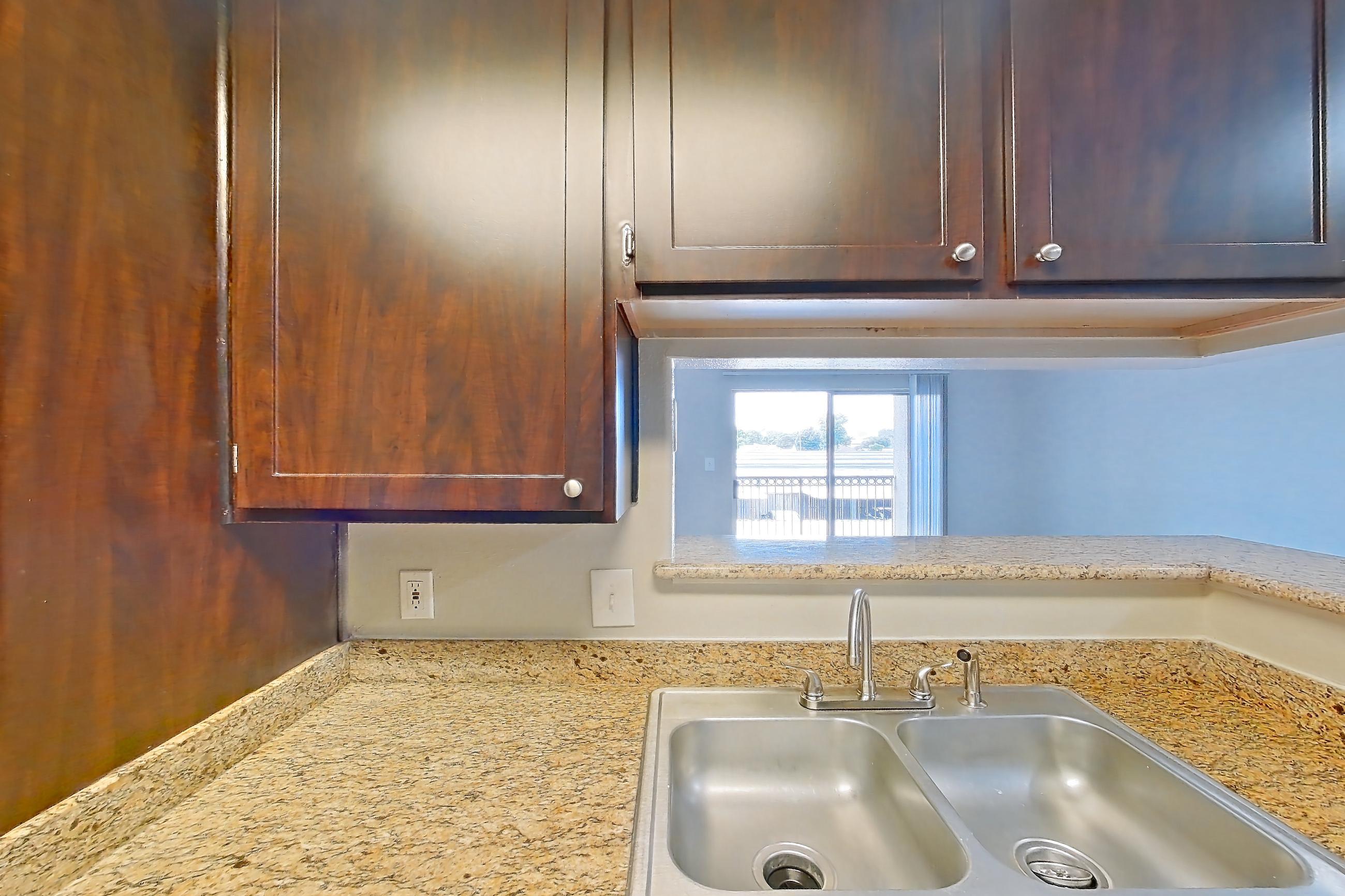 Kitchen with black appliances, dishwasher, electric range, light stone countertops, light wood-finish flooring, oven/range, and refrigerator, Apartment 0425 at Marquis on Westheimer