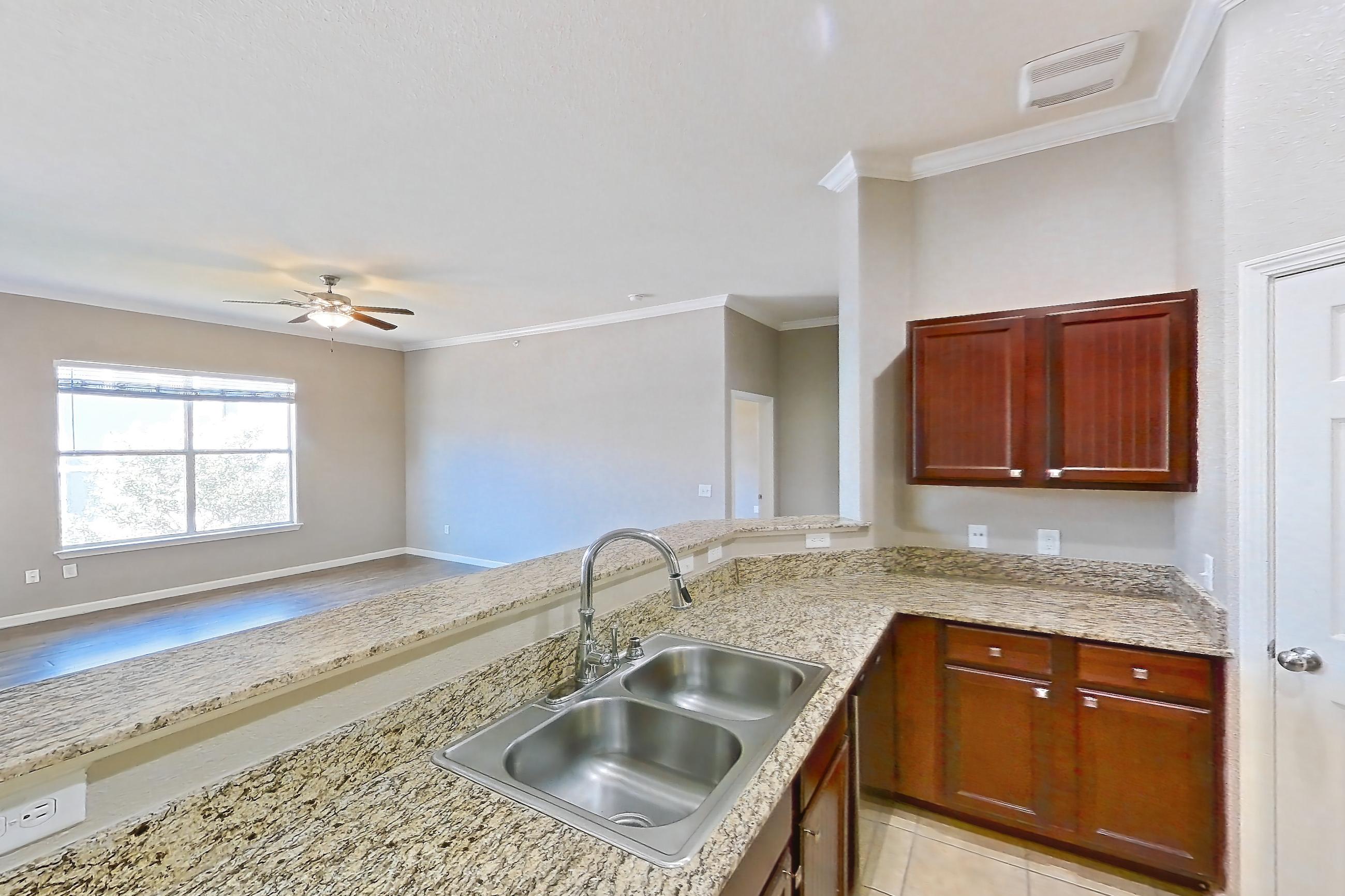 Kitchen with light stone countertops and light tile flooring, Apartment 0847 at Marquis at Crown Ridge