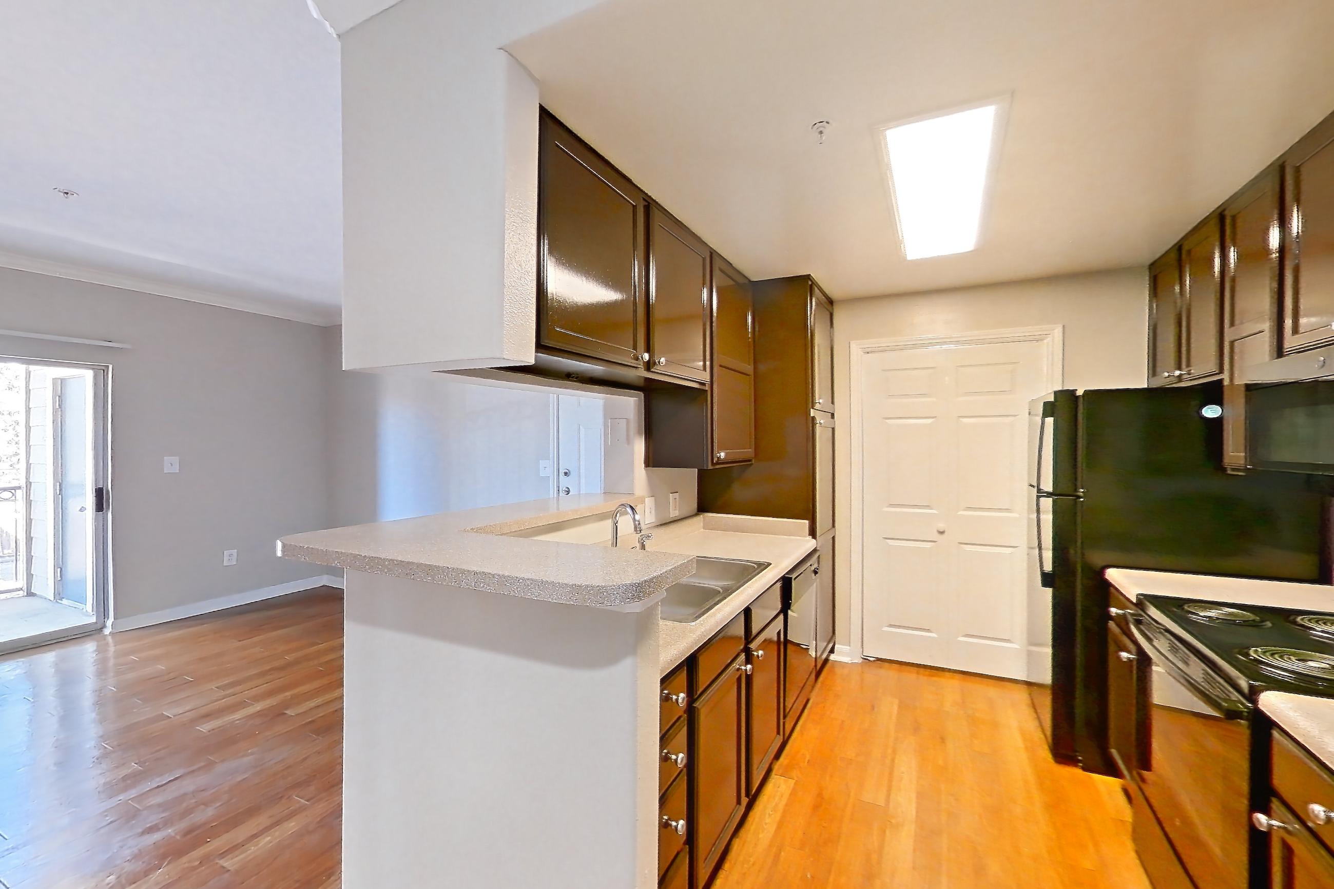 Dining room with black appliances, electric range, light countertops, light wood-finish flooring, oven/range, refrigerator, and wood-finish flooring, Apartment 0428 at Marquis on Westheimer