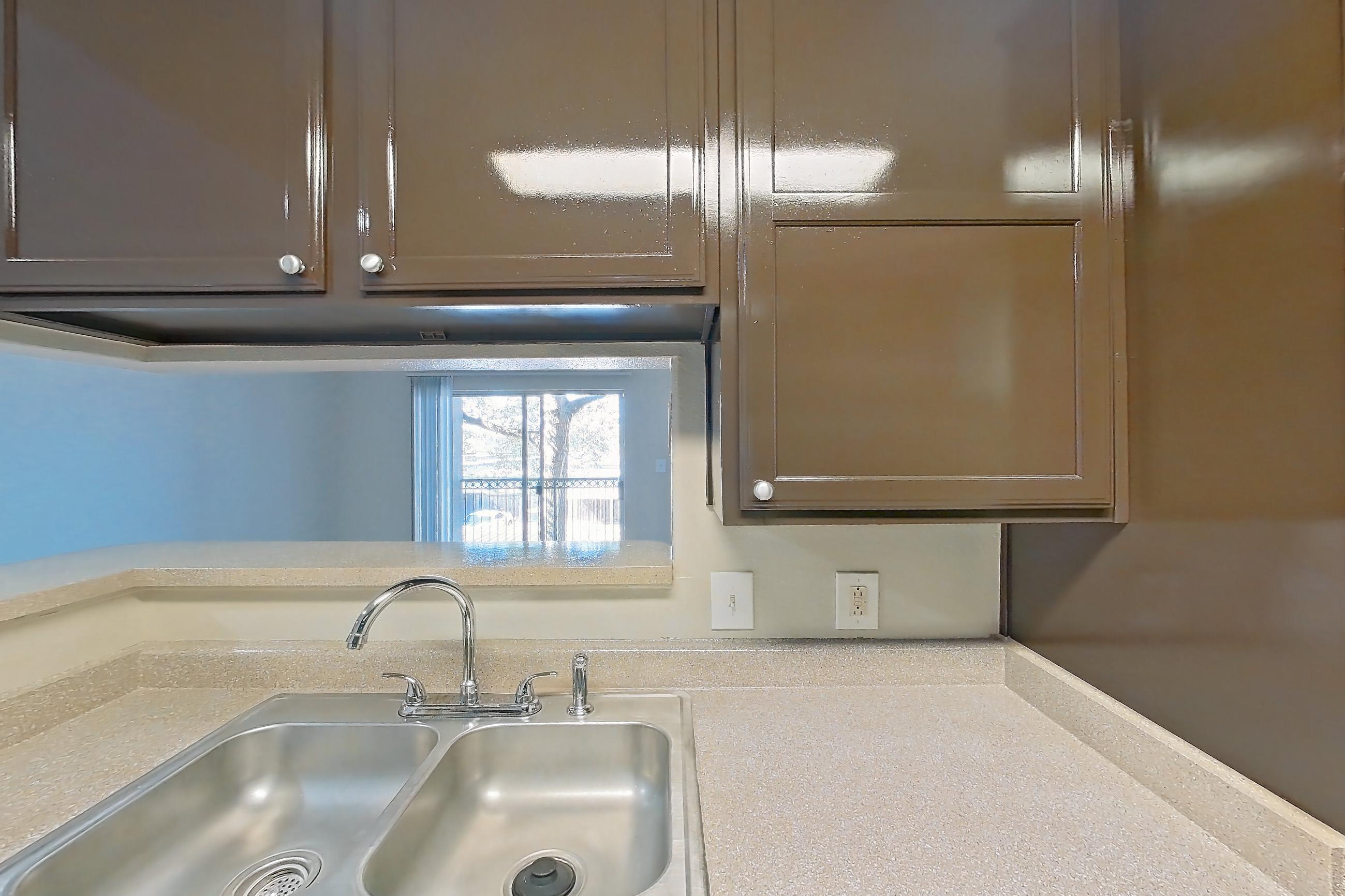 Kitchen with black appliances, dishwasher, electric range, light stone countertops, light wood-finish flooring, oven/range, refrigerator, and stainless steel appliances, Apartment 0428 at Marquis on Westheimer
