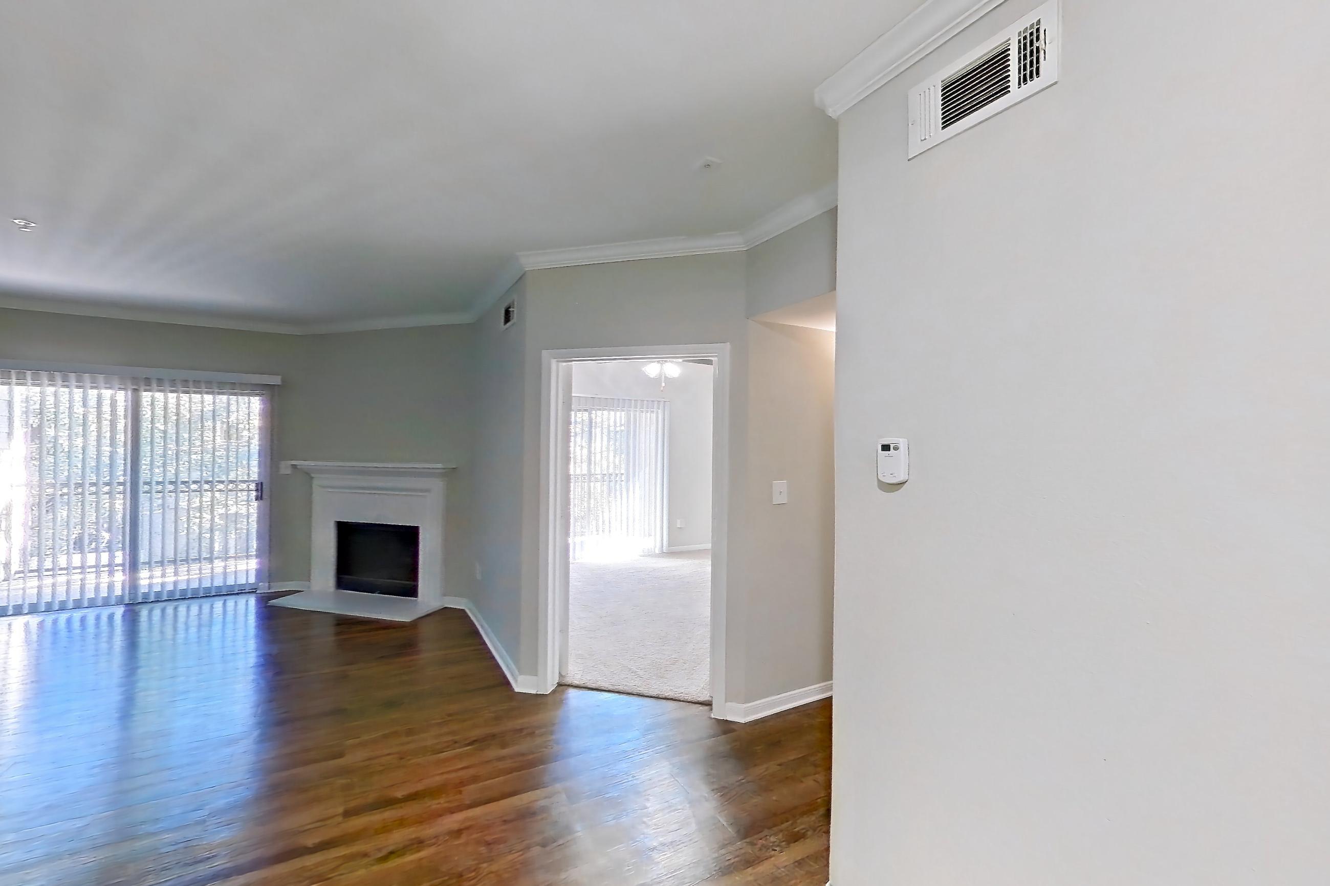 Dining room with dark carpet, dark wood-finish flooring, dishwasher, electric range, fireplace, light stone countertops, light wood-finish flooring, oven/range, refrigerator, and stainless steel appliances, Apartment 0433 at Marquis on Westheimer