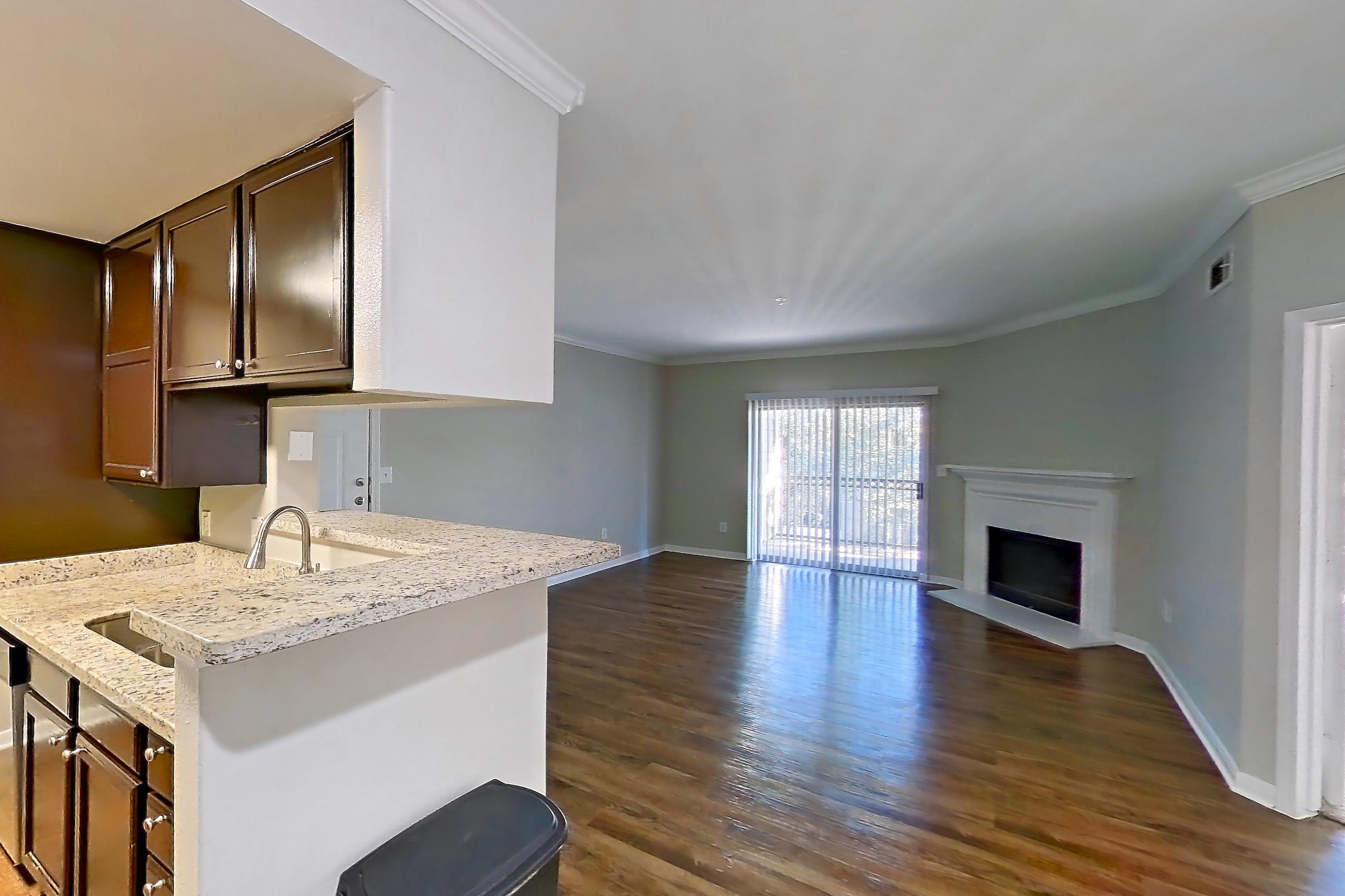 Dining room with dark carpet, dark wood-finish flooring, dishwasher, electric range, fireplace, light stone countertops, light wood-finish flooring, oven/range, refrigerator, and stainless steel appliances, Apartment 0433 at Marquis on Westheimer