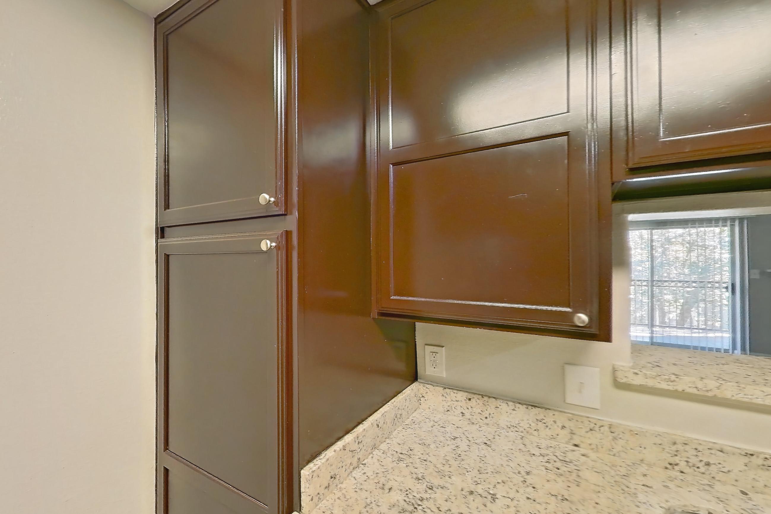 Kitchen with dishwasher, electric range, light stone countertops, light wood-finish flooring, microwave, oven/range, refrigerator, stainless steel appliances, and white appliances, Apartment 0433 at Marquis on Westheimer