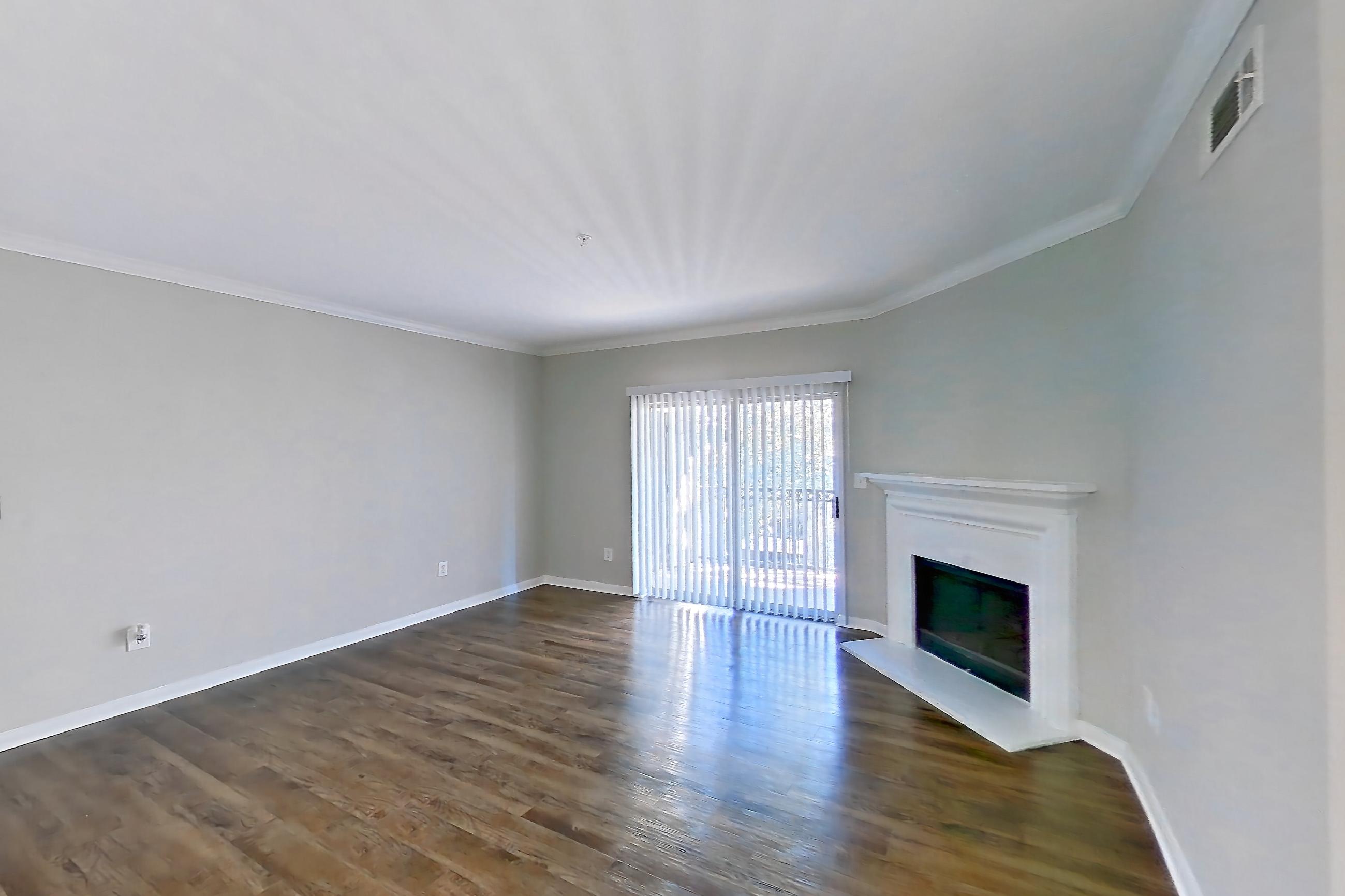 Living space with dark carpet, dark wood-finish flooring, electric range, fireplace, light stone countertops, oven/range, and stainless steel appliances, Apartment 0433 at Marquis on Westheimer
