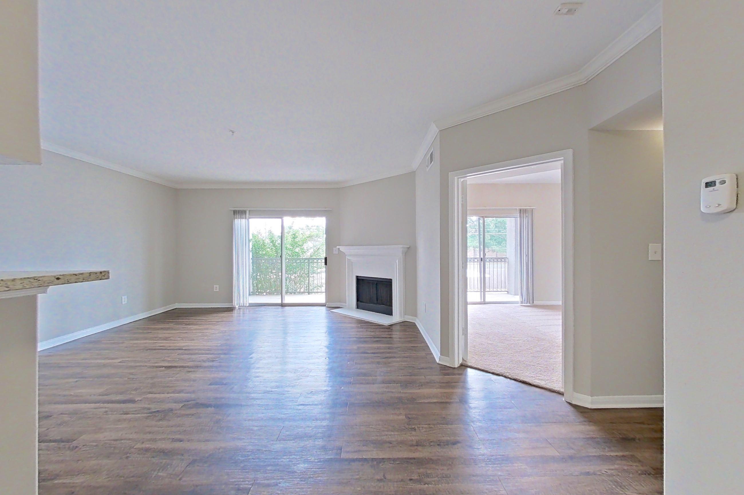 Dining room with dark wood-finish flooring, electric range, fireplace, light countertops, light stone countertops, oven/range, and stainless steel appliances, Apartment 0525 at Marquis on Westheimer