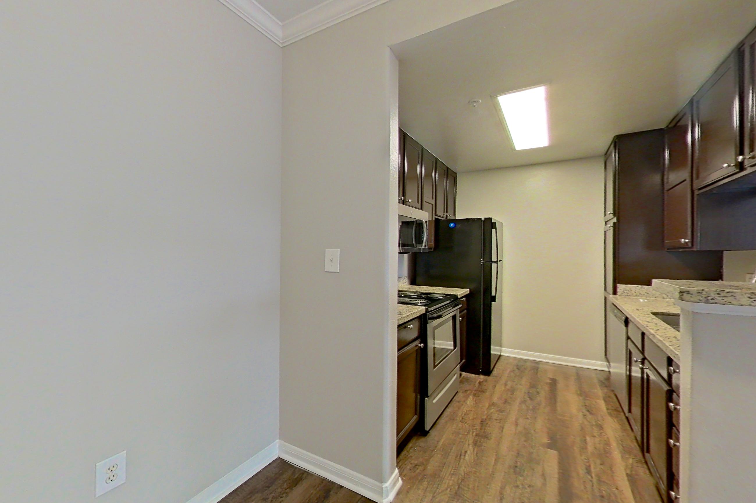 Dining room with dark wood-finish flooring, electric range, fireplace, light countertops, light stone countertops, oven/range, and stainless steel appliances, Apartment 0525 at Marquis on Westheimer