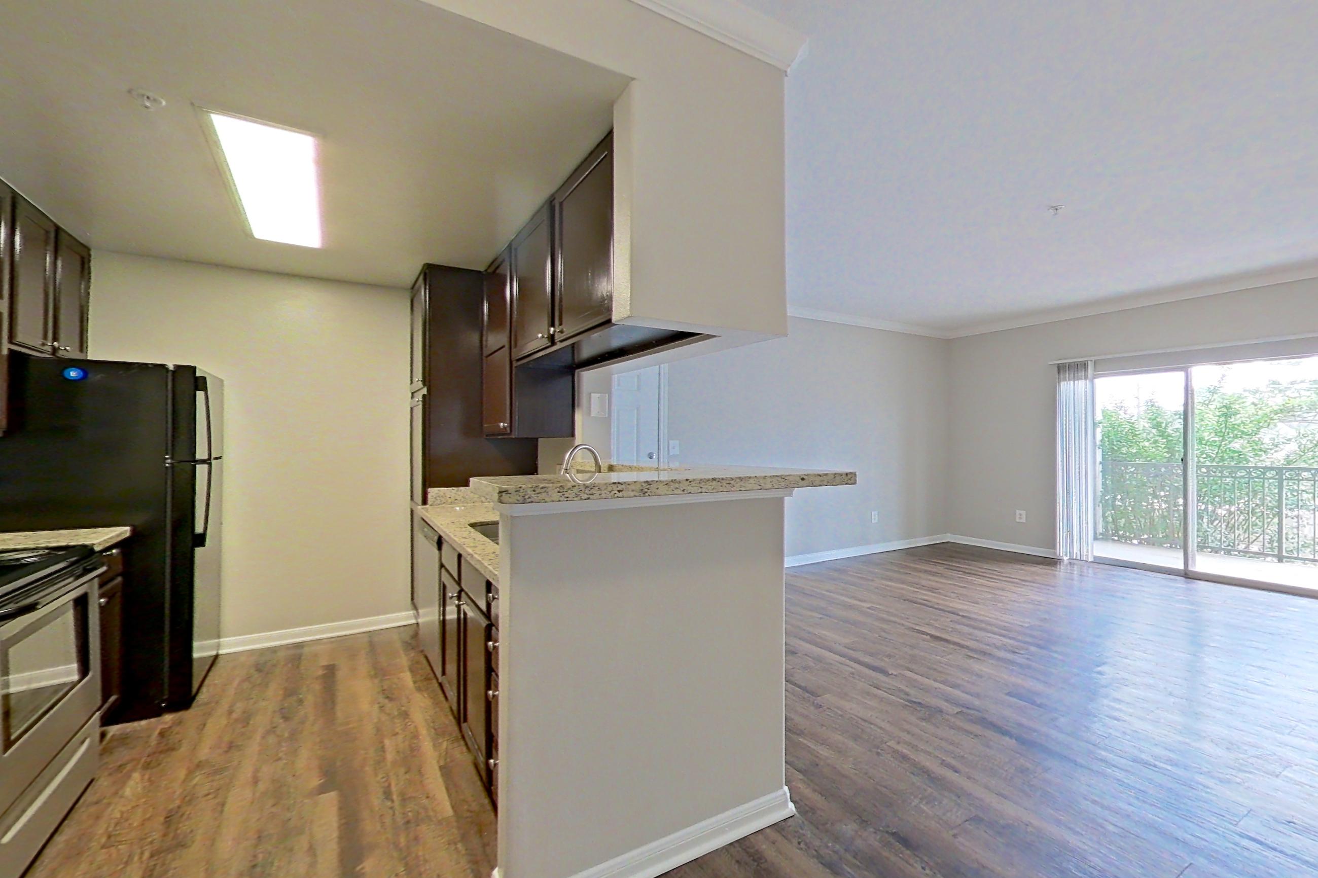 Dining room with dark wood-finish flooring, electric range, fireplace, light countertops, light stone countertops, oven/range, and stainless steel appliances, Apartment 0525 at Marquis on Westheimer
