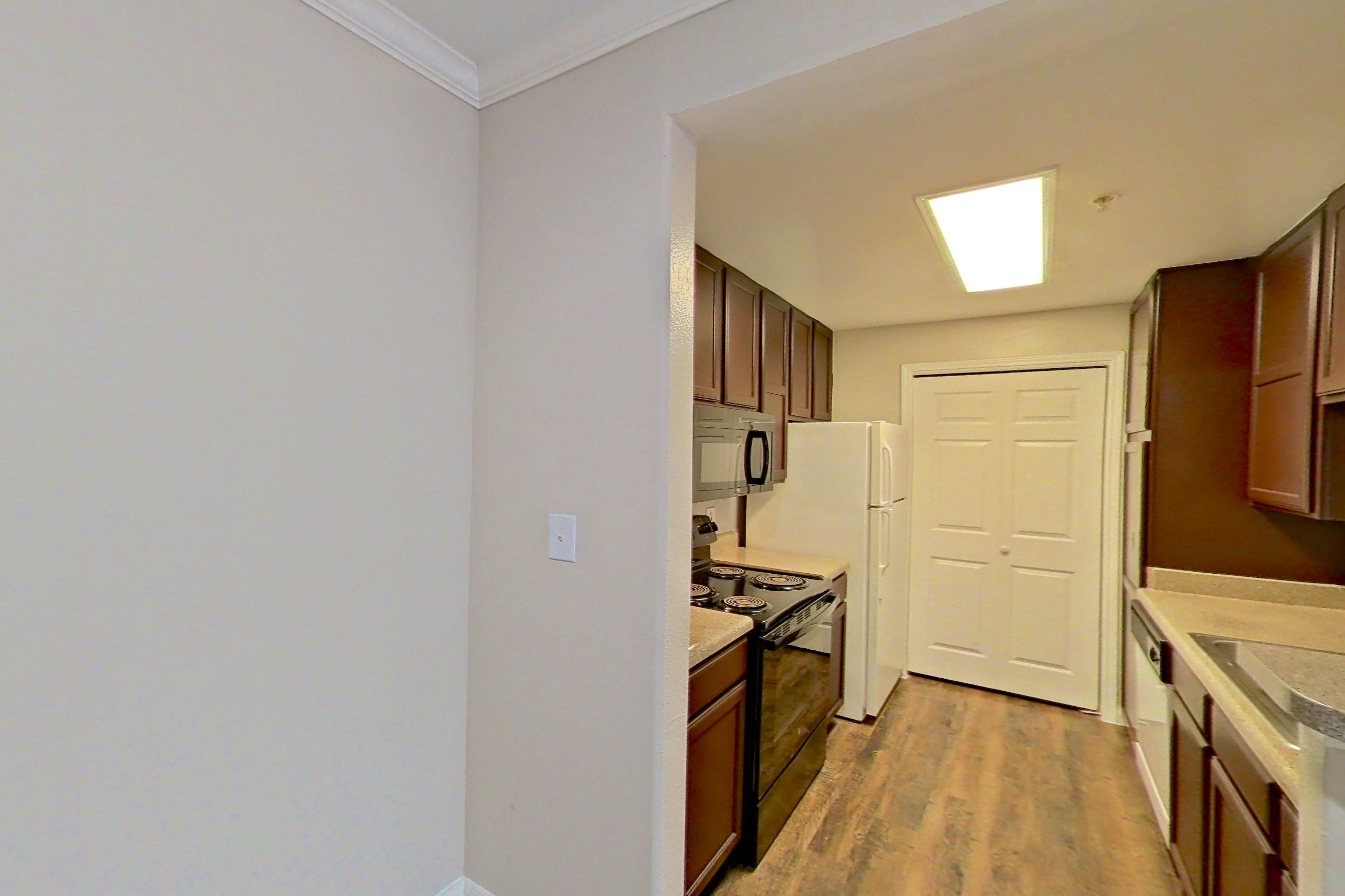 Dining area with dark wood-finish flooring, electric range, light countertops, refrigerator, and white appliances, Apartment 0631 at Marquis on Westheimer