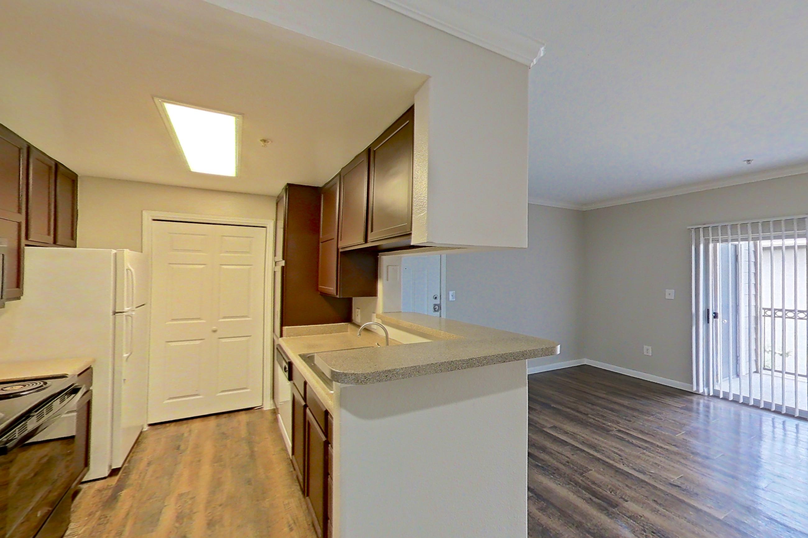 Dining area with dark wood-finish flooring, electric range, light countertops, refrigerator, and white appliances, Apartment 0631 at Marquis on Westheimer