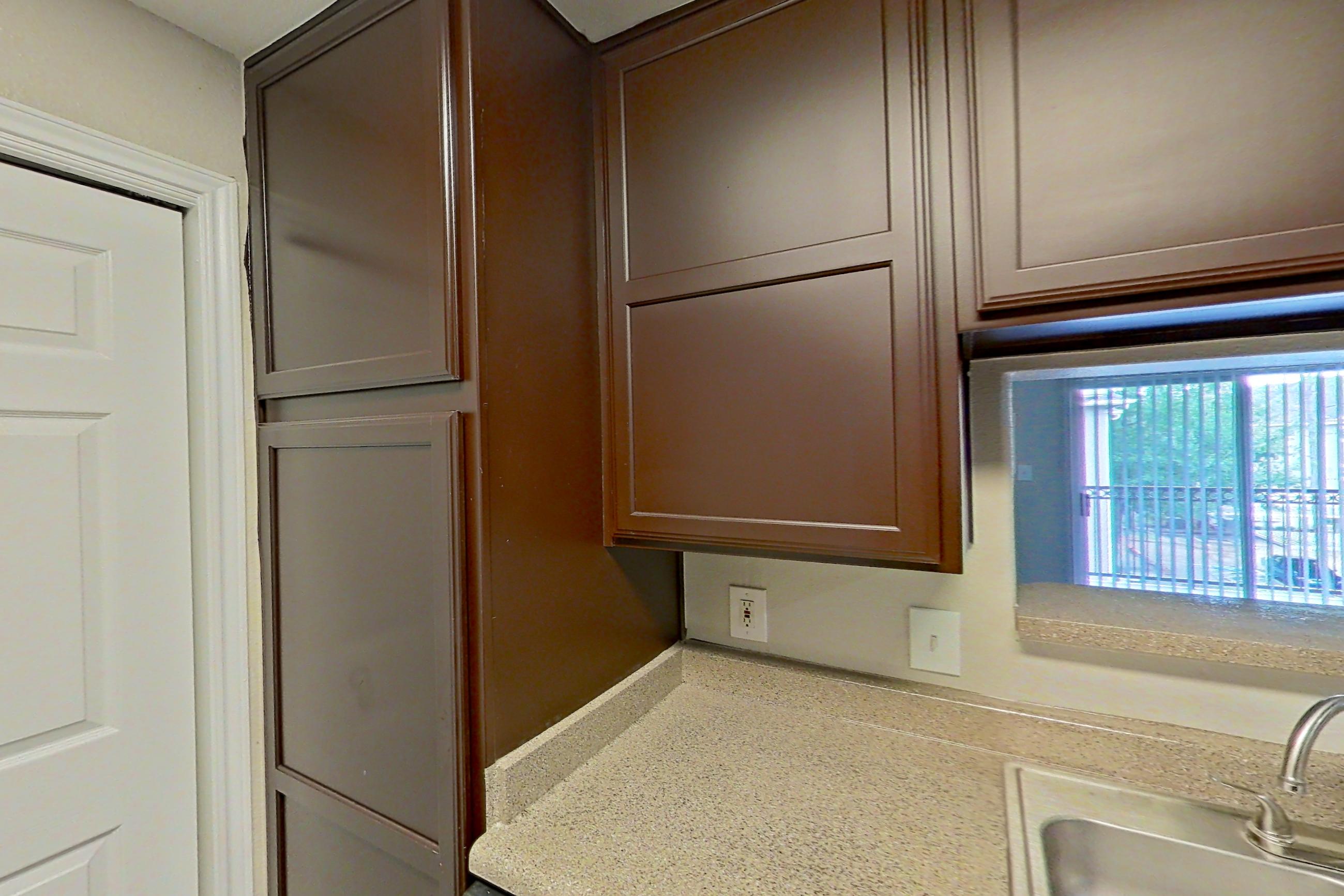 Kitchen with black appliances, dishwasher, electric range, light countertops, microwave, oven/range, refrigerator, and white appliances, Apartment 0631 at Marquis on Westheimer