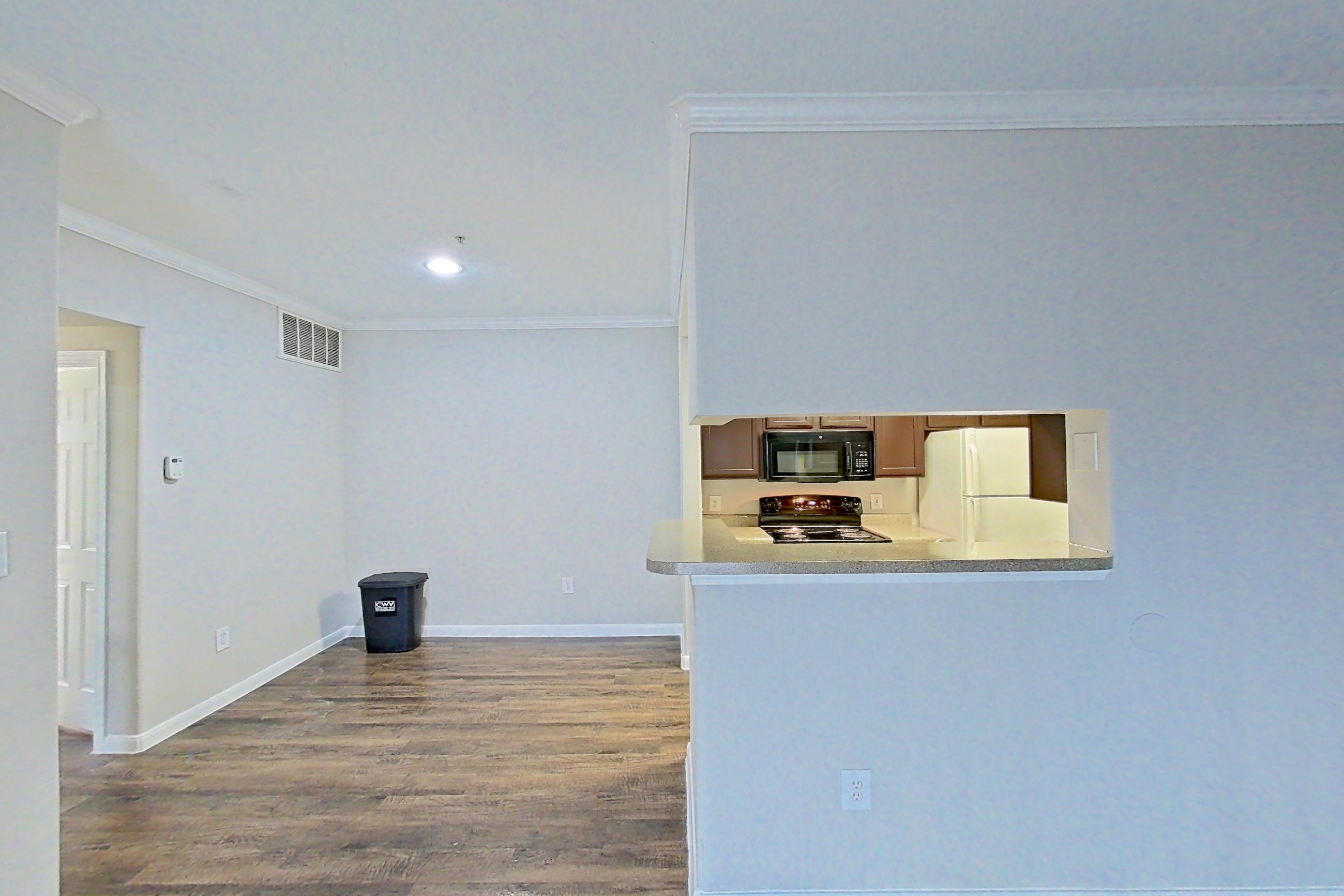 Living room with black appliances, dark wood-finish flooring, electric range, light countertops, oven/range, refrigerator, and white appliances, Apartment 0631 at Marquis on Westheimer