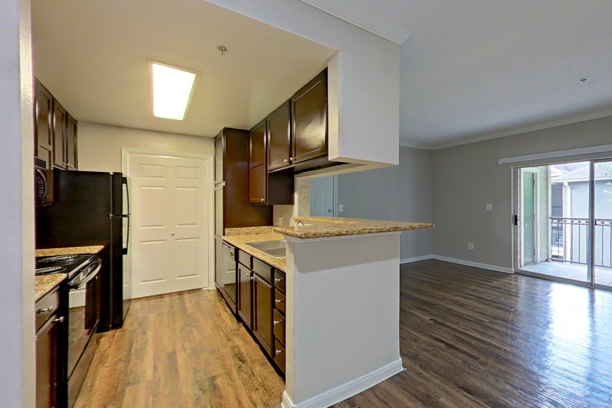 Dining room with dark wood-finish flooring and light stone countertops, Apartment 0635 at Marquis on Westheimer