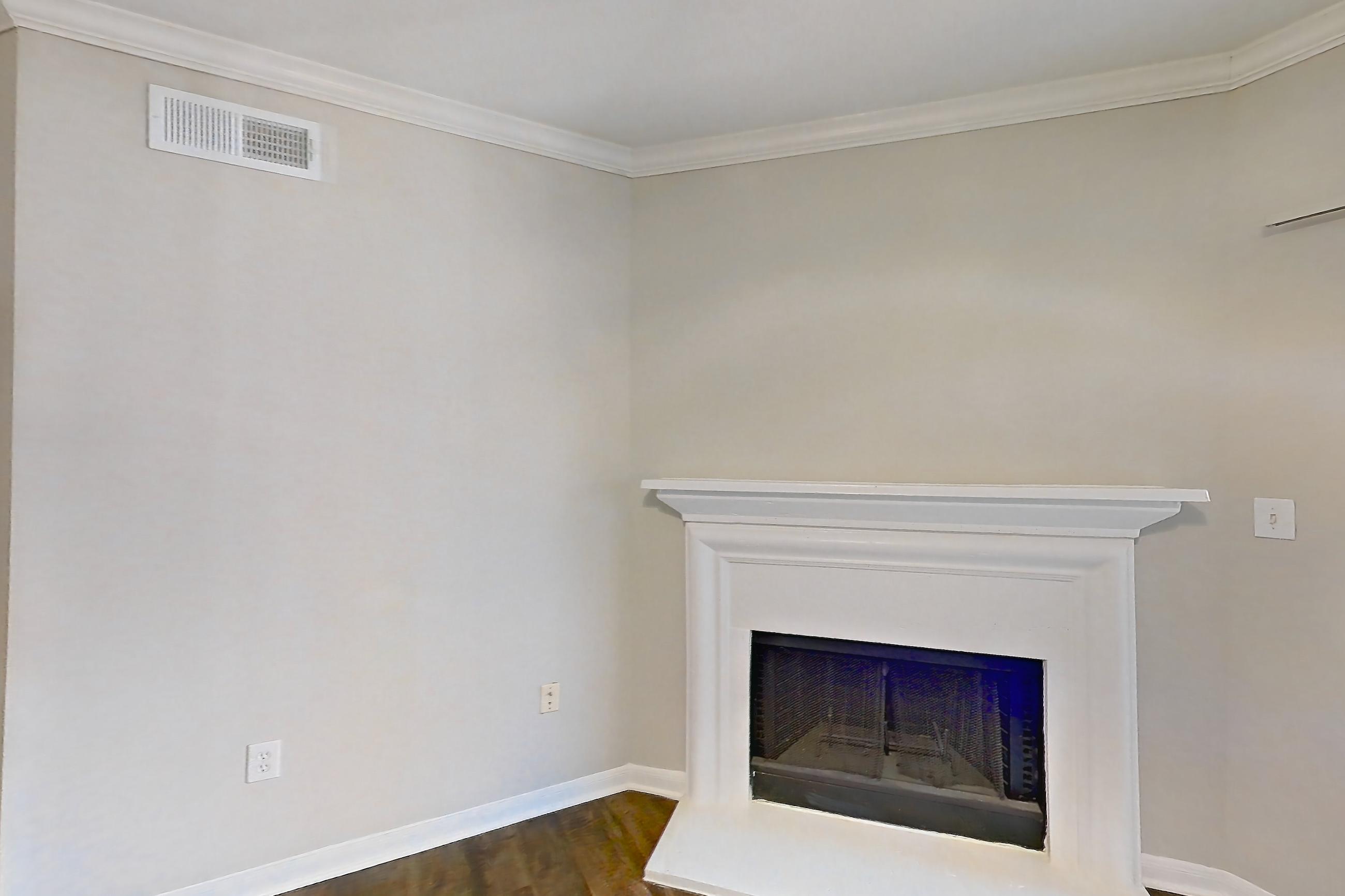Living room with dark wood-finish flooring and fireplace, Apartment 0636 at Marquis on Westheimer