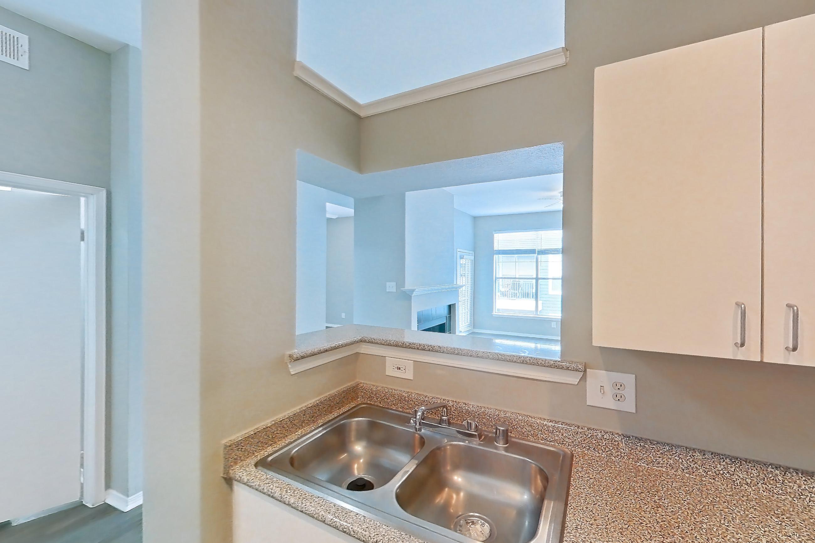 Kitchen with dishwasher, electric range, light countertops, light stone countertops, light wood-finish flooring, microwave, oven/range, refrigerator, and white appliances, Apartment 01-01313 at Marquis on Gaston