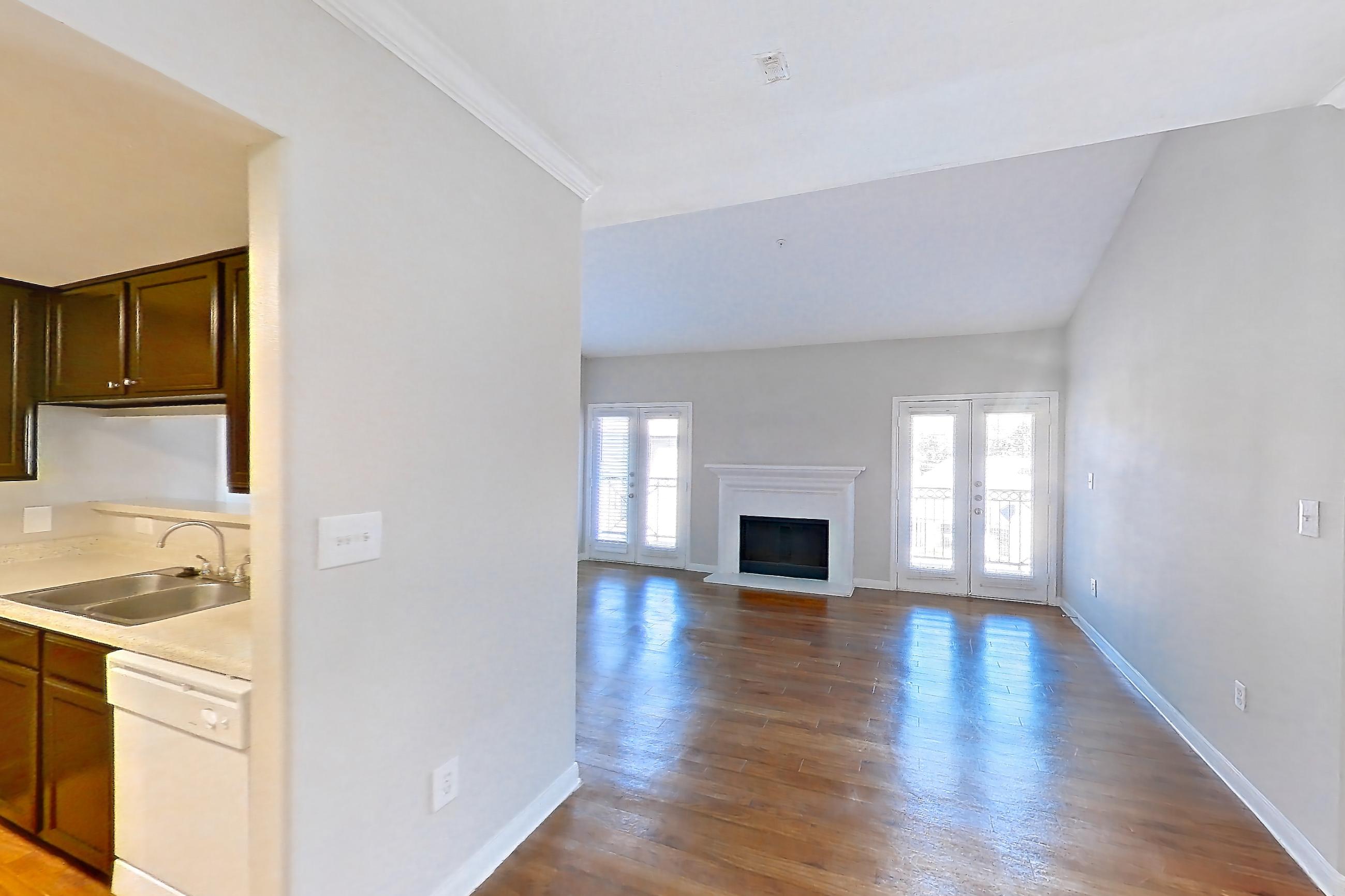 Dining room with dishwasher, electric range, fireplace, light countertops, light wood-finish flooring, oven/range, refrigerator, white appliances, and wood-finish flooring, Apartment 0732 at Marquis on Westheimer