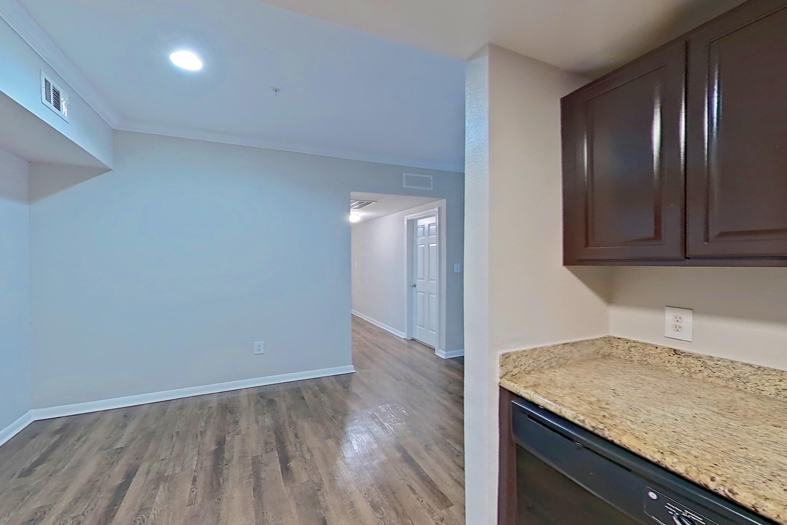 Kitchen with black appliances, dishwasher, electric range, light countertops, light stone countertops, light wood-finish flooring, microwave, oven/range, and refrigerator, Apartment 0821 at Marquis on Westheimer