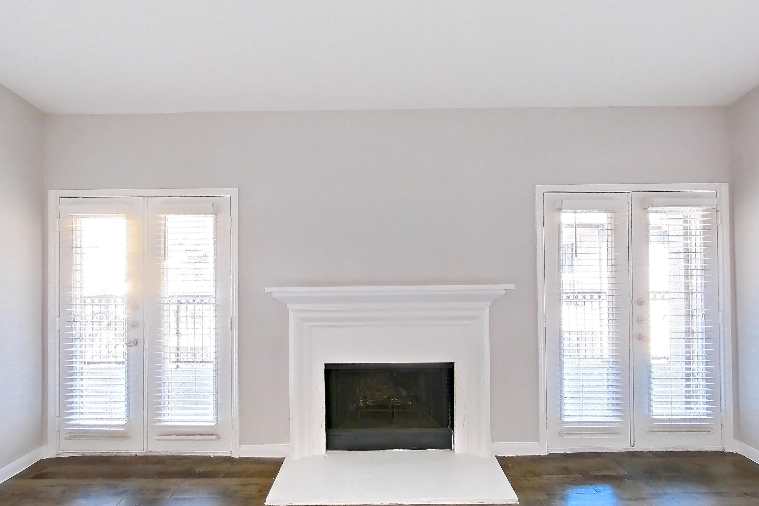 Living room with dark wood-finish flooring and fireplace, Apartment 0832 at Marquis on Westheimer