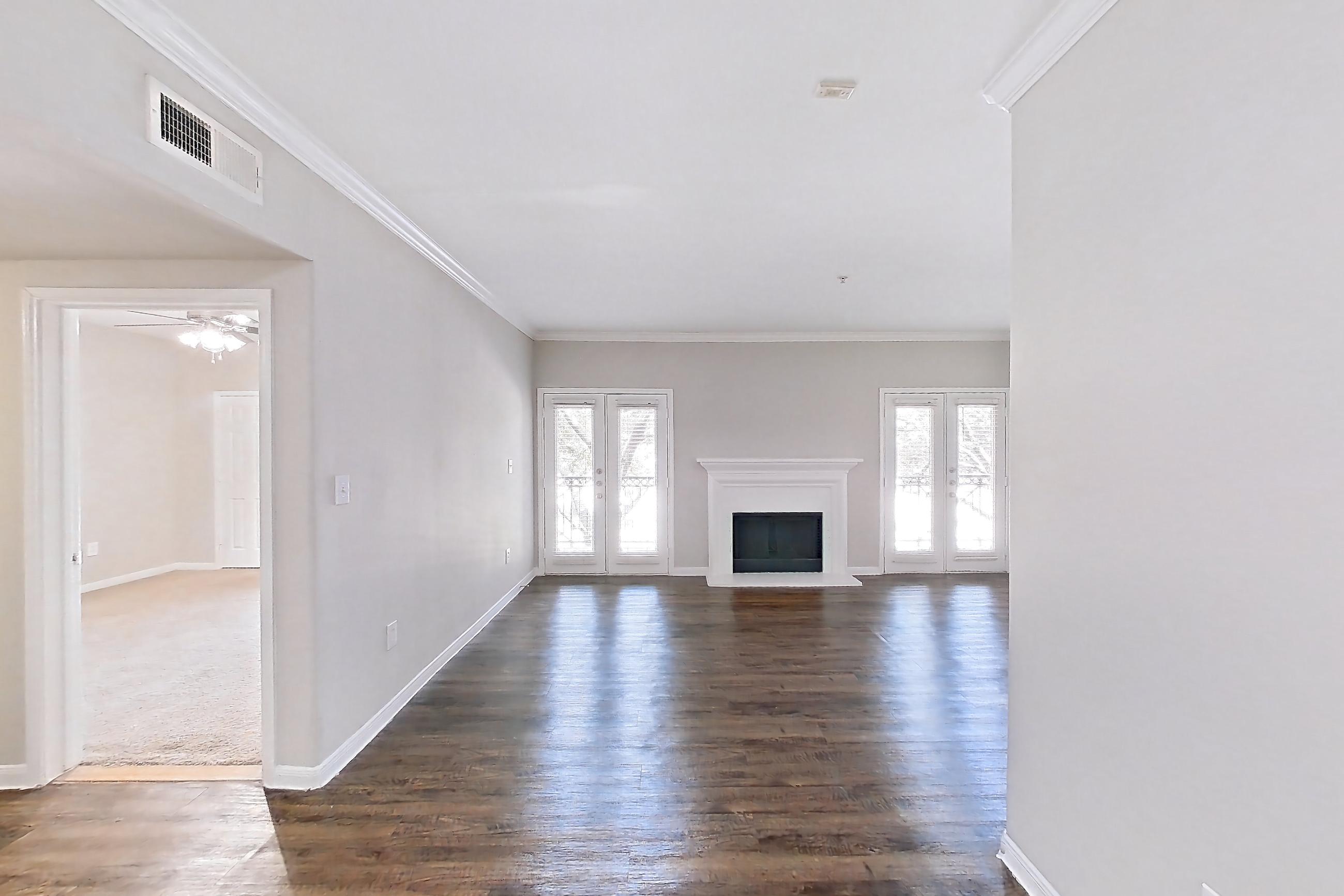 Dining room with black appliances, dark wood-finish flooring, dishwasher, electric range, fireplace, light countertops, light wood-finish flooring, oven/range, range hood, refrigerator, and white appliances, Apartment 0923 at Marquis on Westheimer