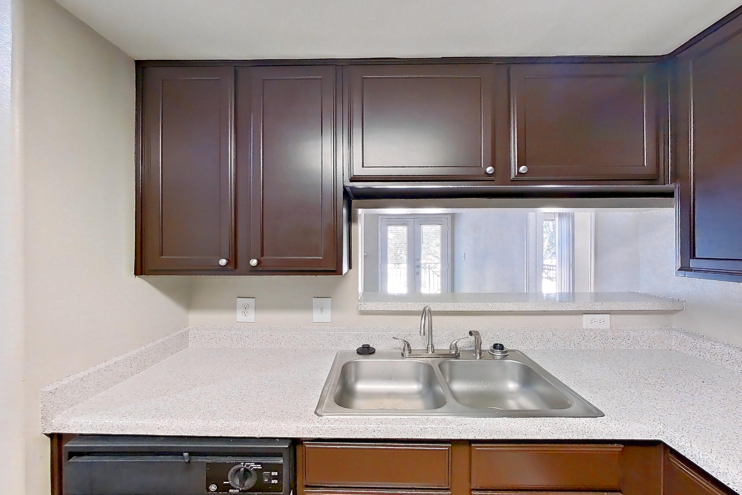 Kitchen with black appliances, dishwasher, electric range, light countertops, light stone countertops, light wood-finish flooring, microwave, oven/range, and white appliances, Apartment 0923 at Marquis on Westheimer