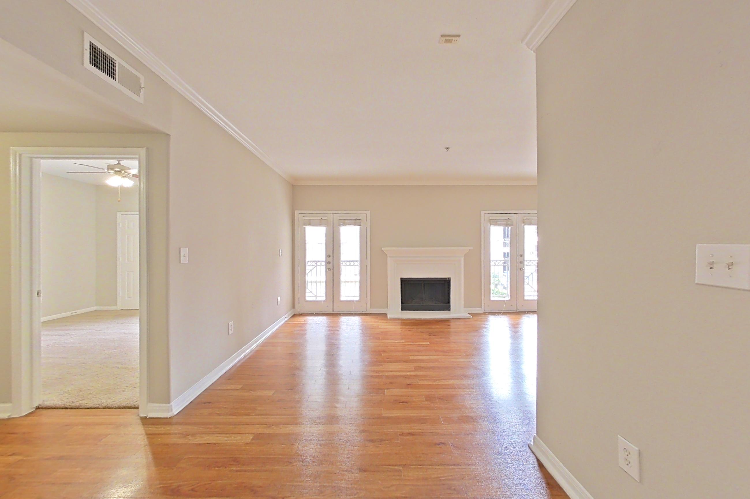 Dining room with electric range, fireplace, light stone countertops, light wood-finish flooring, microwave, oven/range, refrigerator, stainless steel appliances, and wood-finish flooring, Apartment 0927 at Marquis on Westheimer
