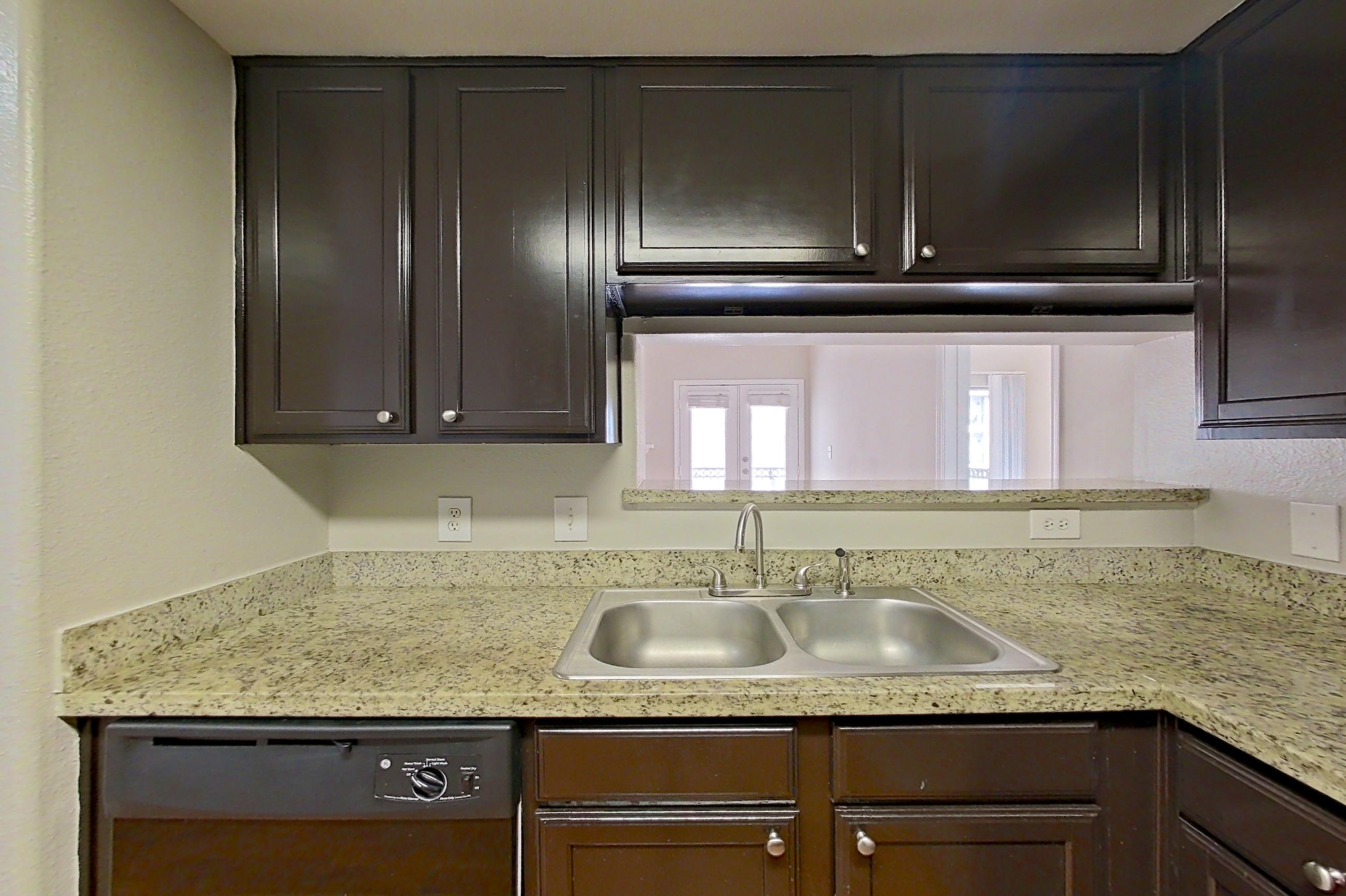 Kitchen with black appliances, dishwasher, electric range, light stone countertops, light wood-finish flooring, microwave, oven/range, and stainless steel appliances, Apartment 0927 at Marquis on Westheimer