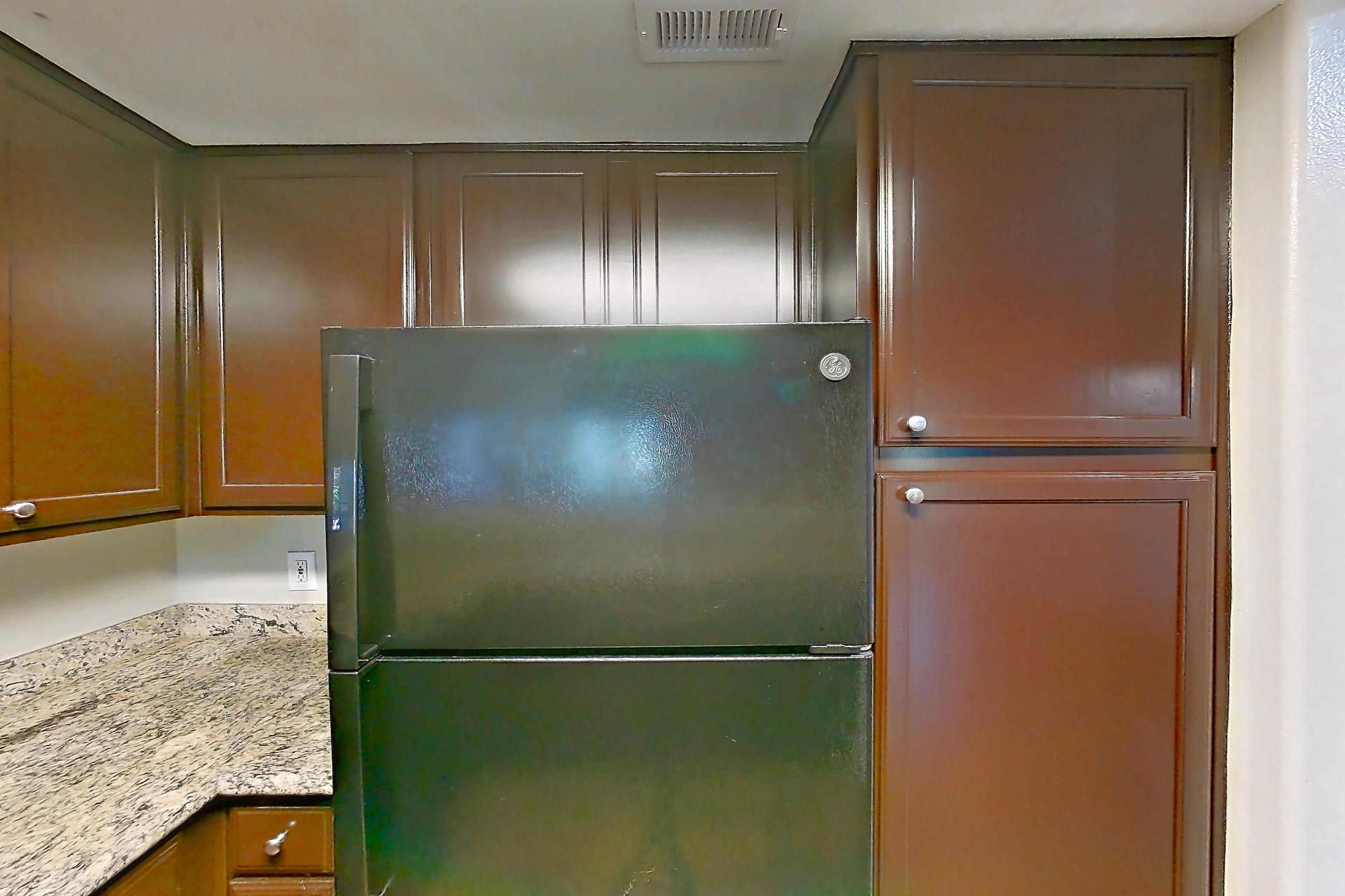 Kitchen with black appliances, dishwasher, electric range, glass shower door, light stone countertops, light wood-finish flooring, microwave, oven/range, refrigerator, stall shower, and walk-in shower, Apartment 0933 at Marquis on Westheimer