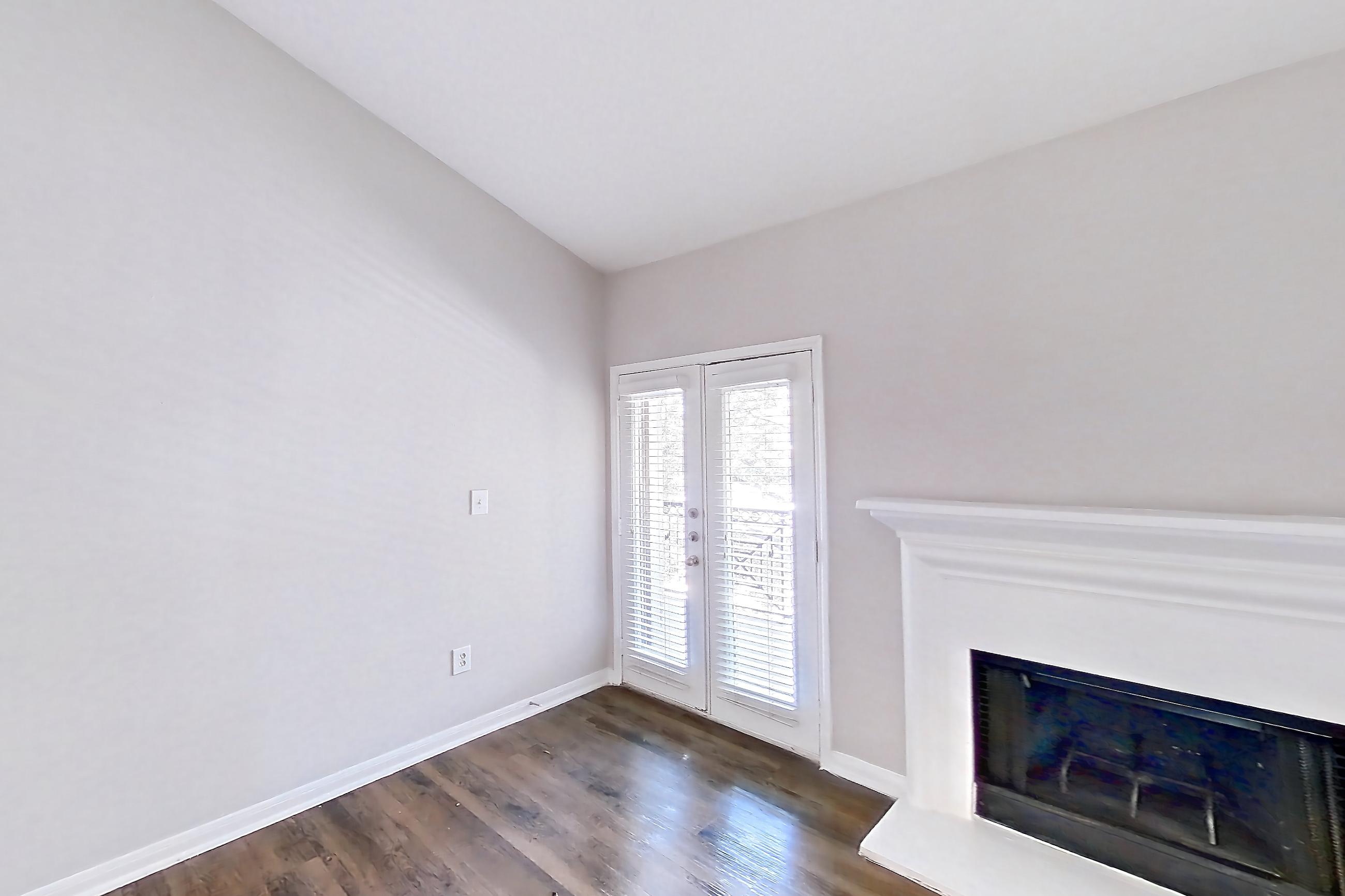 Living room with black appliances, dark wood-finish flooring, fireplace, and oven/range, Apartment 0933 at Marquis on Westheimer