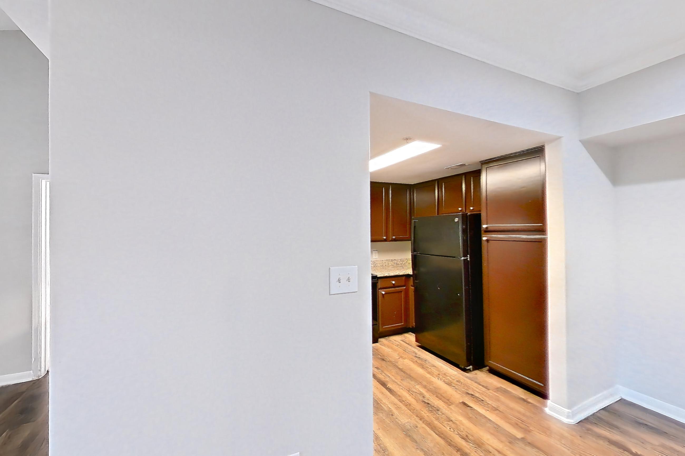 Living space with black appliances, fireplace, light wood-finish flooring, and refrigerator, Apartment 0933 at Marquis on Westheimer