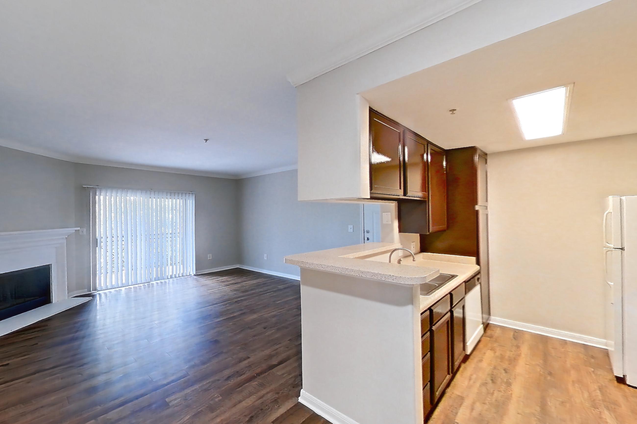 Kitchen space with dark wood-finish flooring, electric range, light countertops, oven/range, and stainless steel appliances, Apartment 0934 at Marquis on Westheimer