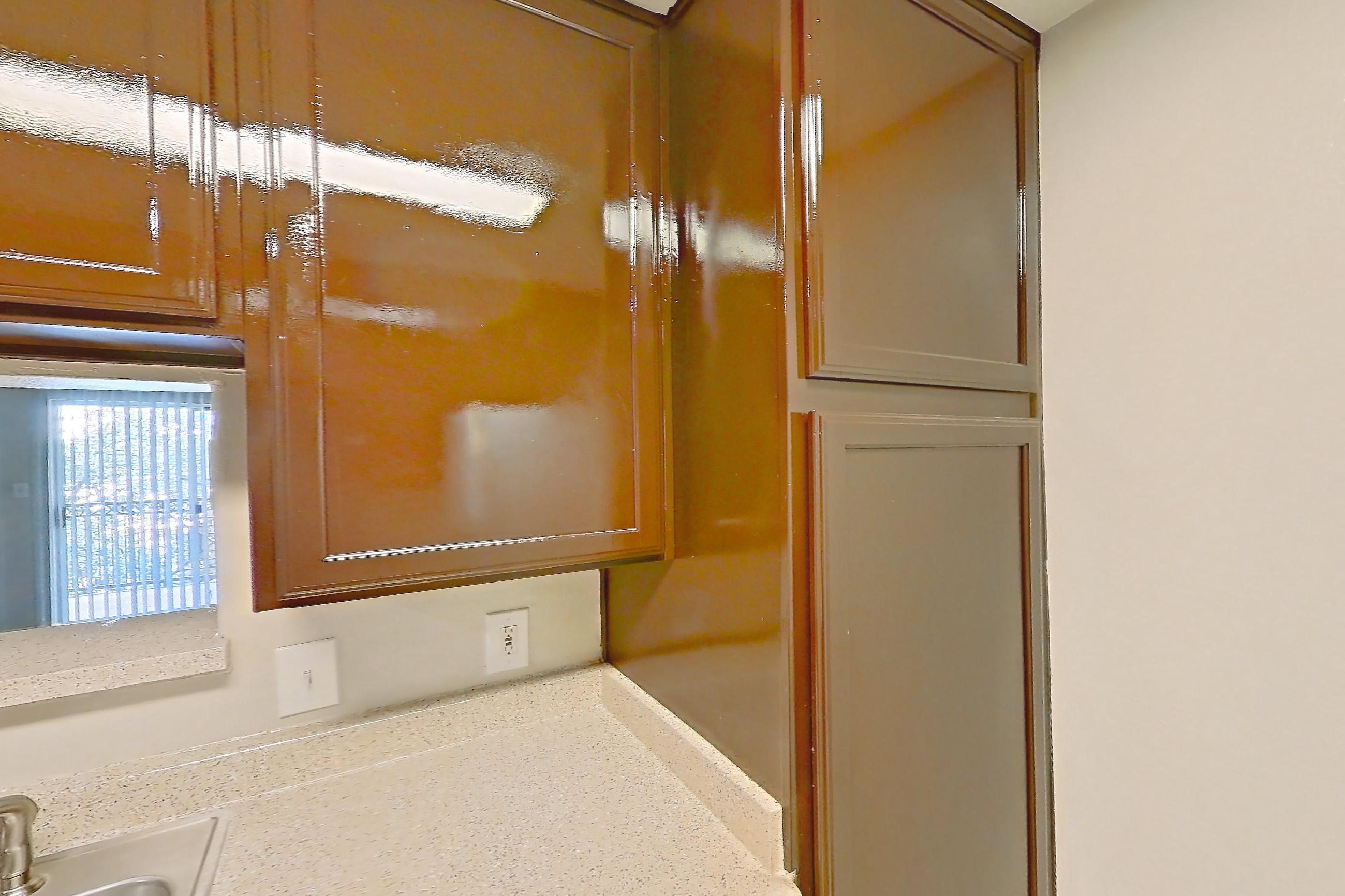 Kitchen with black appliances, dishwasher, electric range, light countertops, light stone countertops, light wood-finish flooring, microwave, oven/range, refrigerator, and white appliances, Apartment 0934 at Marquis on Westheimer