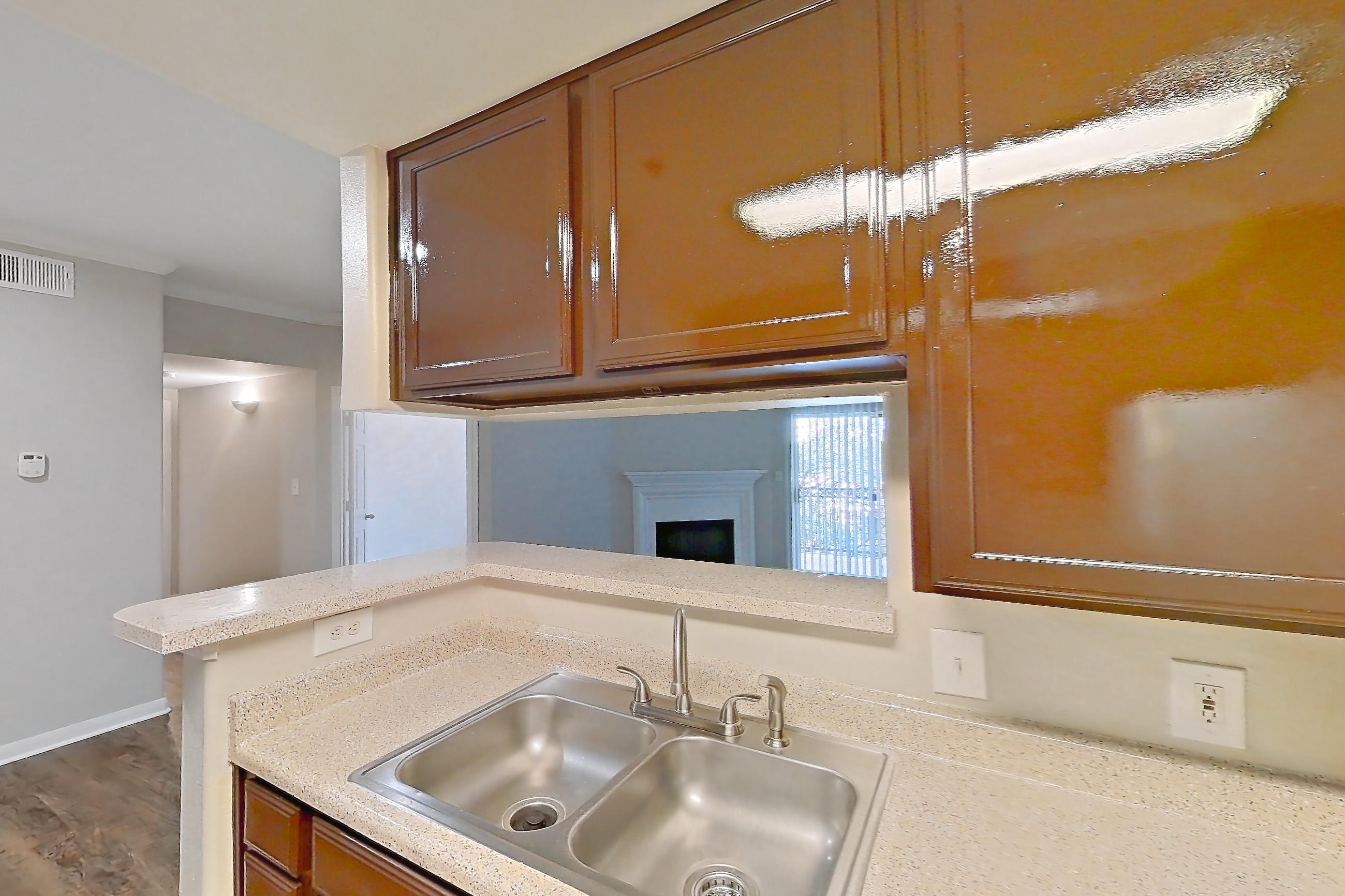 Kitchen with black appliances, dishwasher, electric range, light countertops, light stone countertops, light wood-finish flooring, microwave, oven/range, refrigerator, and white appliances, Apartment 0934 at Marquis on Westheimer