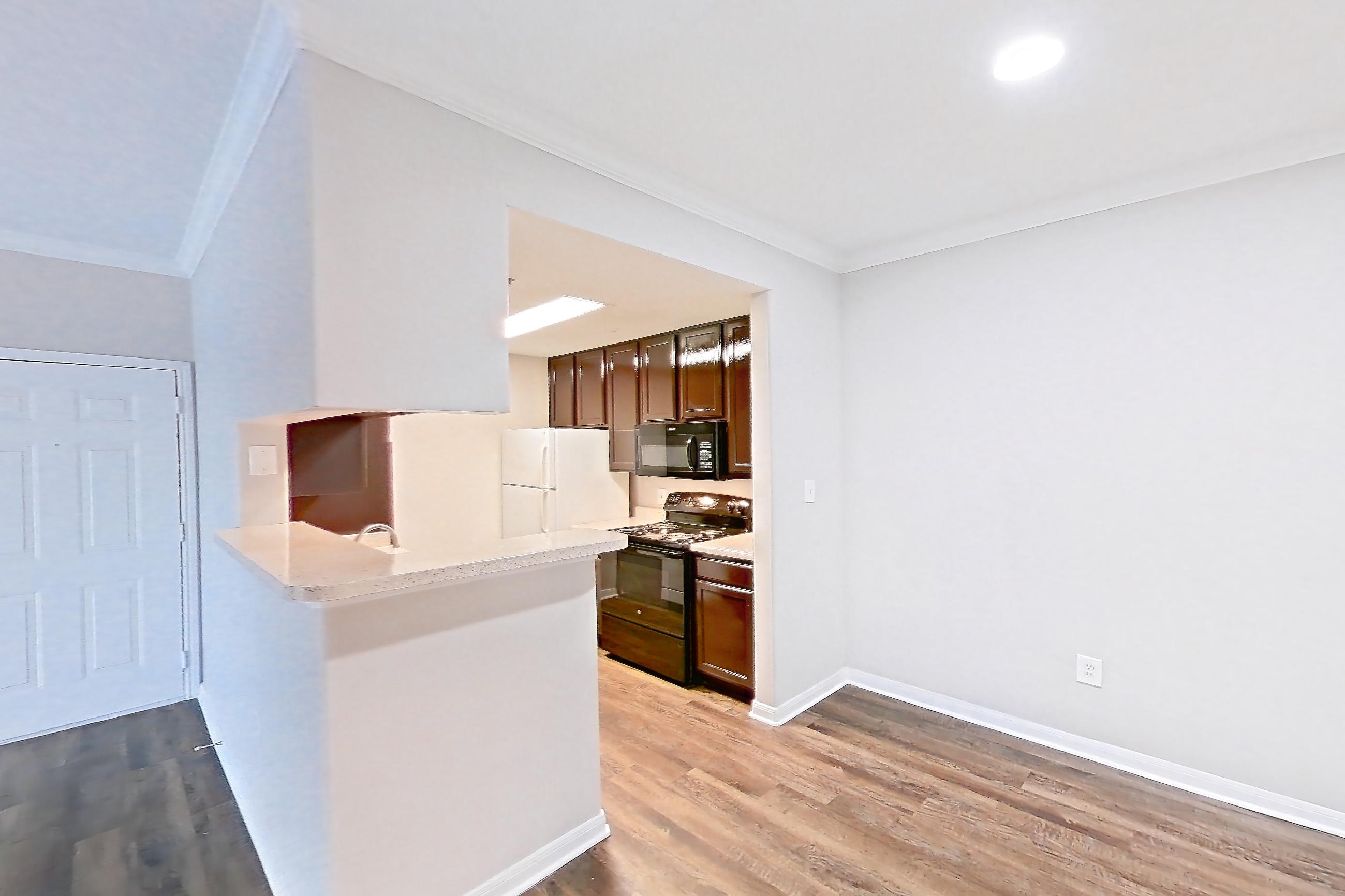 Living space with black appliances, dark wood-finish flooring, electric range, light countertops, and oven/range, Apartment 0934 at Marquis on Westheimer