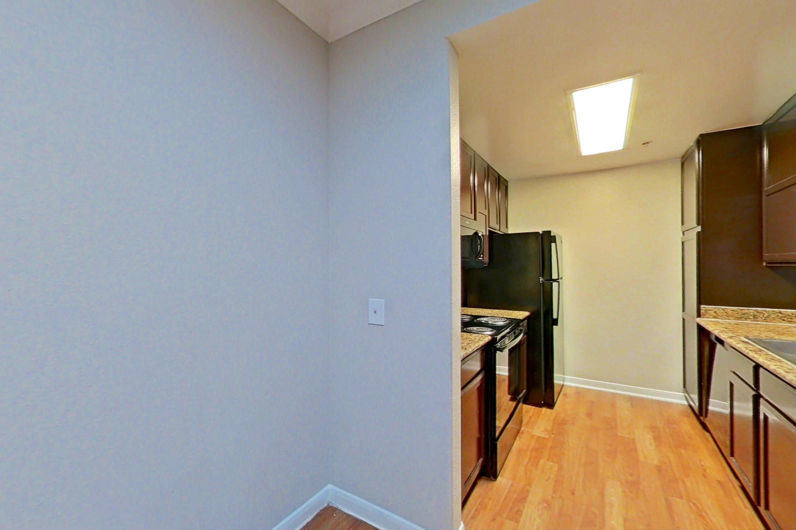 Dining room with electric range, light countertops, light stone countertops, and light wood-finish flooring, Apartment 1217 at Marquis on Westheimer