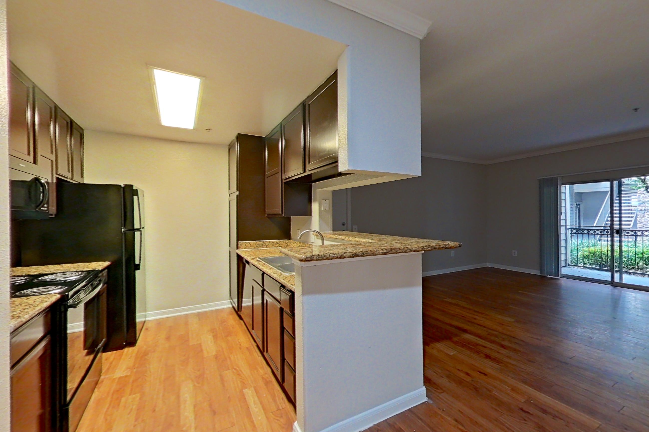 Dining room with electric range, light countertops, light stone countertops, and light wood-finish flooring, Apartment 1217 at Marquis on Westheimer