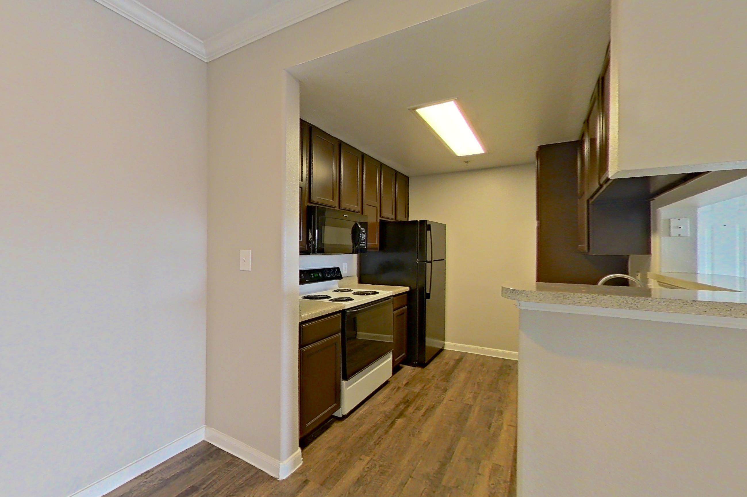 Dining room with dark wood-finish flooring, electric range, fireplace, light countertops, oven/range, and white appliances, Apartment 1223 at Marquis on Westheimer
