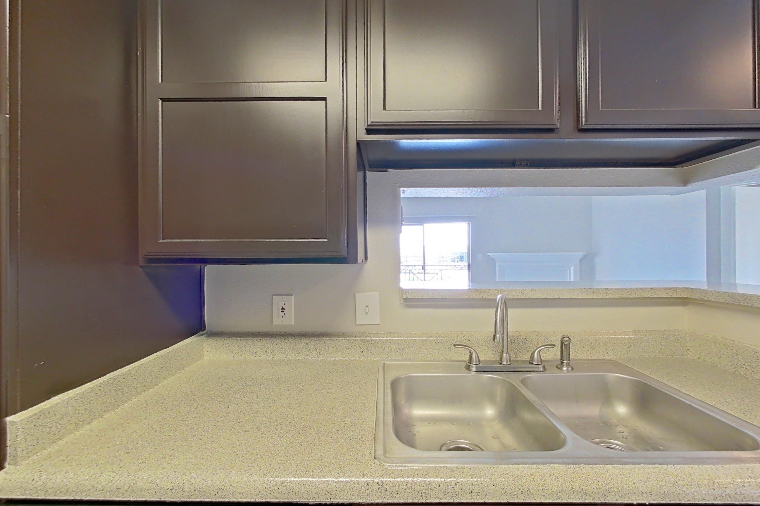 Kitchen with black appliances, dishwasher, light countertops, light stone countertops, refrigerator, and white appliances, Apartment 1223 at Marquis on Westheimer