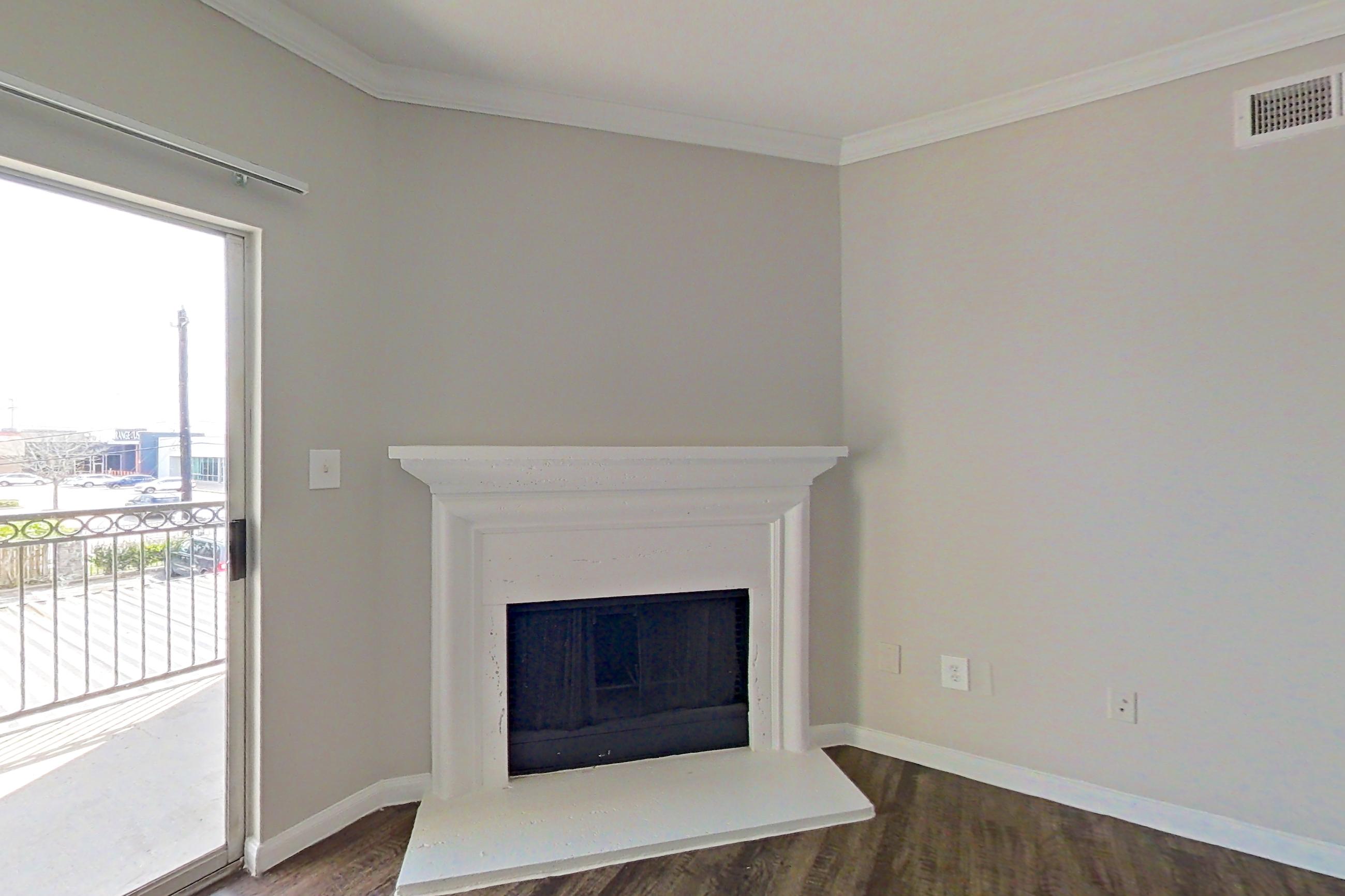 Living room with dark wood-finish flooring and fireplace, Apartment 1223 at Marquis on Westheimer