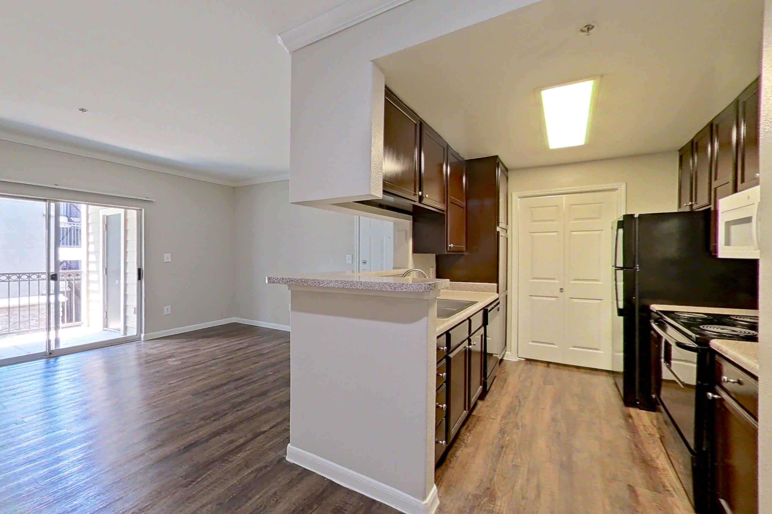 Dining room with black appliances, dark wood-finish flooring, electric range, light countertops, and oven/range, Apartment 1228 at Marquis on Westheimer