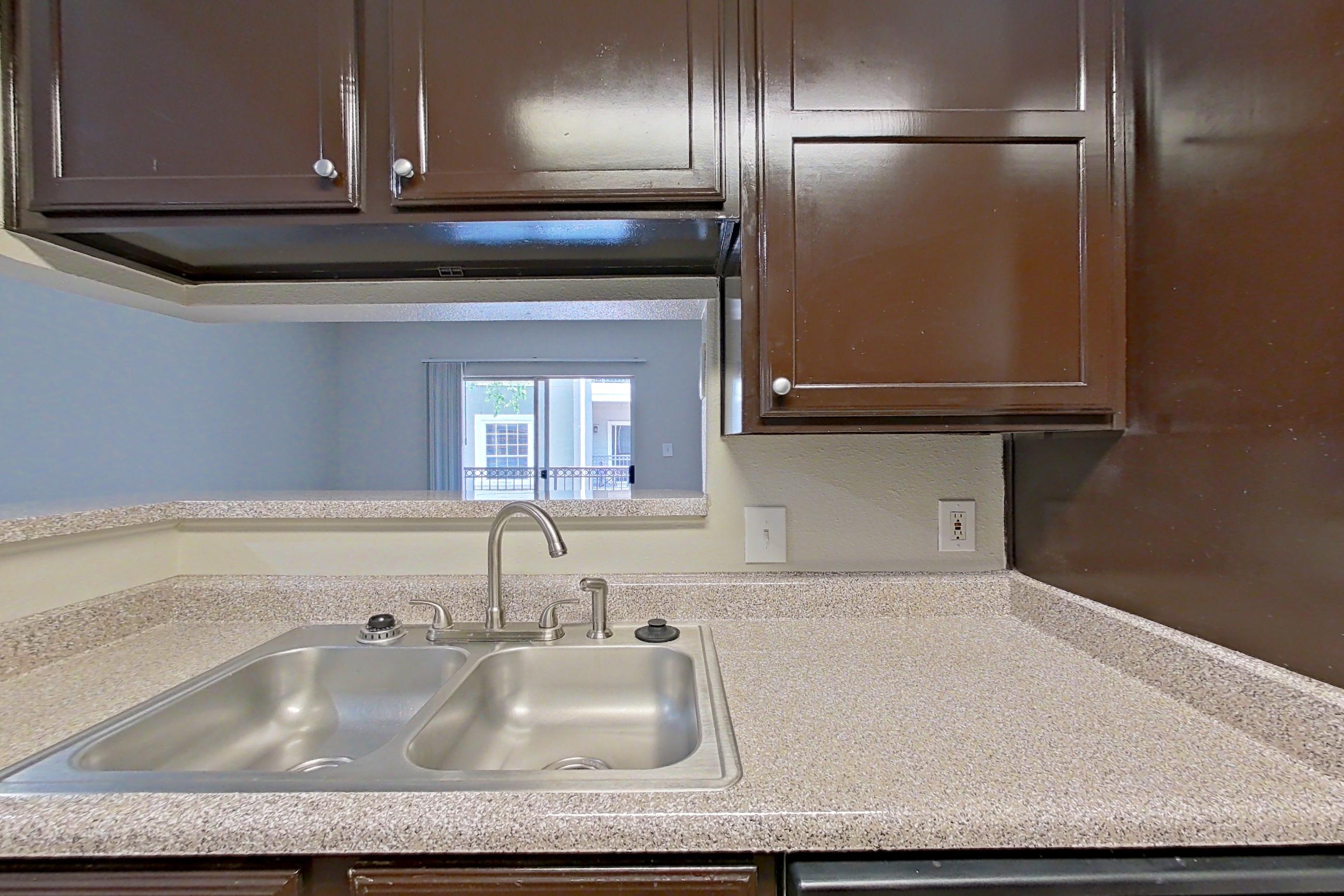 Kitchen with black appliances, dark wood-finish flooring, light countertops, oven/range, and refrigerator, Apartment 1228 at Marquis on Westheimer