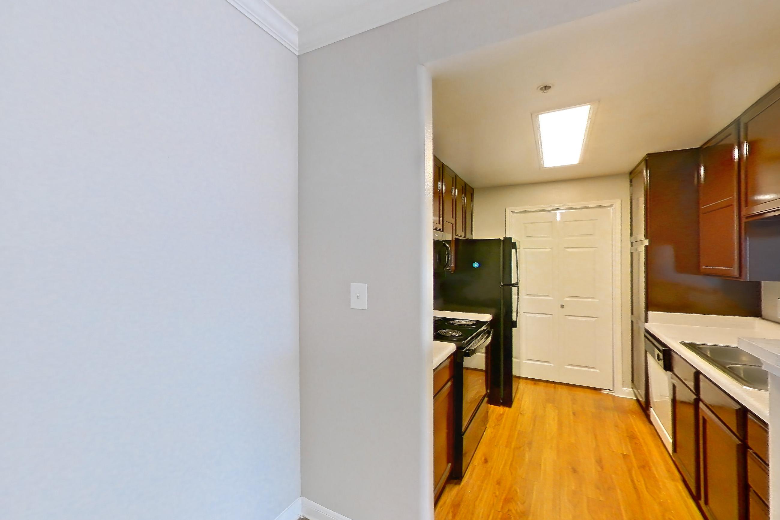 Dining room with black appliances, electric range, light countertops, light wood-finish flooring, oven/range, refrigerator, and wood-finish flooring, Apartment 1325 at Marquis on Westheimer