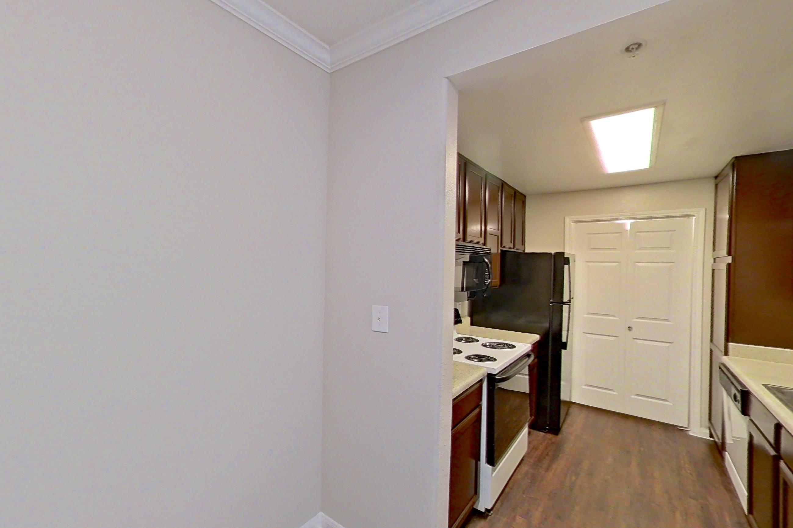 Dining area with black appliances, dark wood-finish flooring, electric range, light countertops, and refrigerator, Apartment 1435 at Marquis on Westheimer