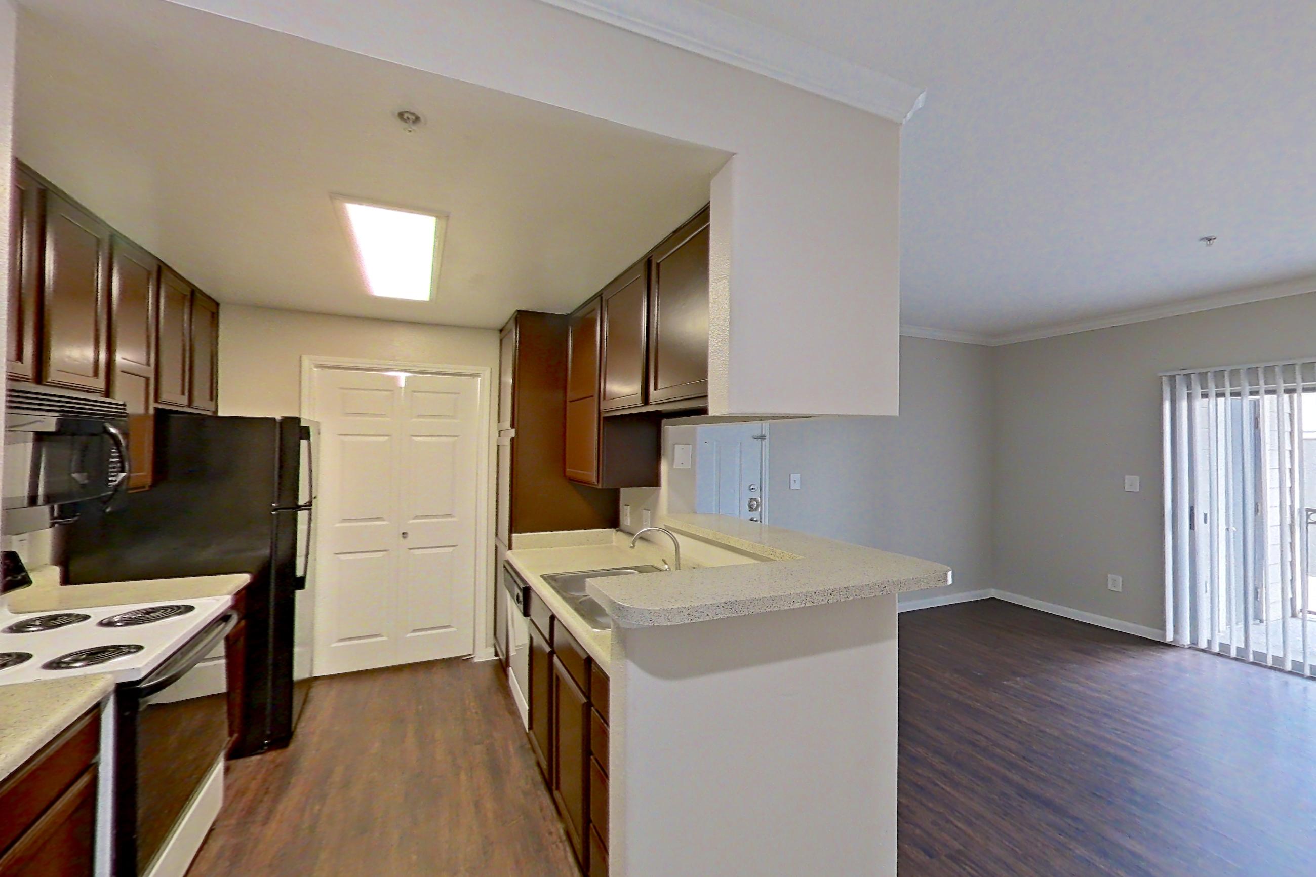 Dining area with black appliances, dark wood-finish flooring, electric range, light countertops, and refrigerator, Apartment 1435 at Marquis on Westheimer