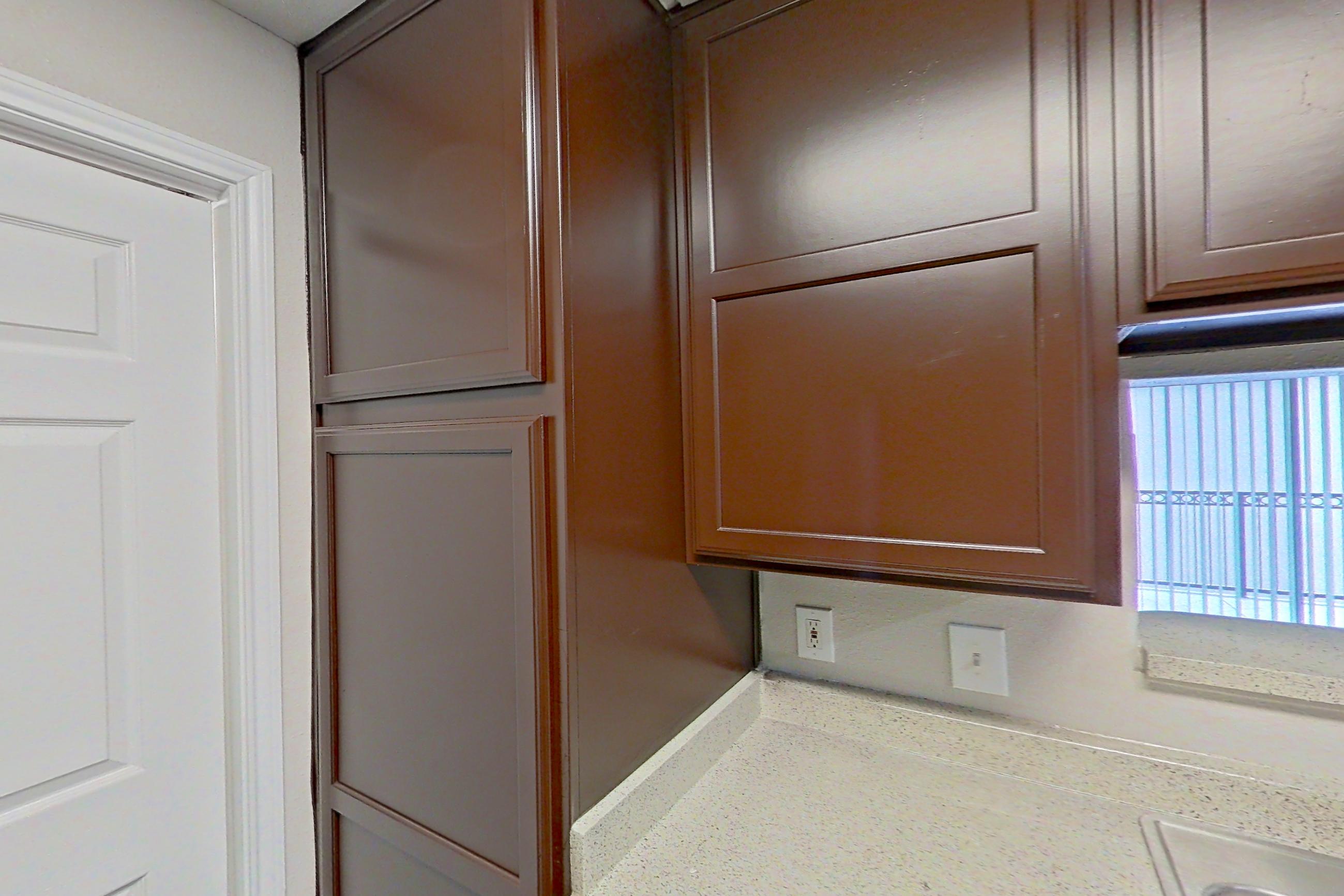Kitchen with black appliances, dark wood-finish flooring, dishwasher, electric range, light countertops, light stone countertops, microwave, oven/range, refrigerator, and white appliances, Apartment 1435 at Marquis on Westheimer