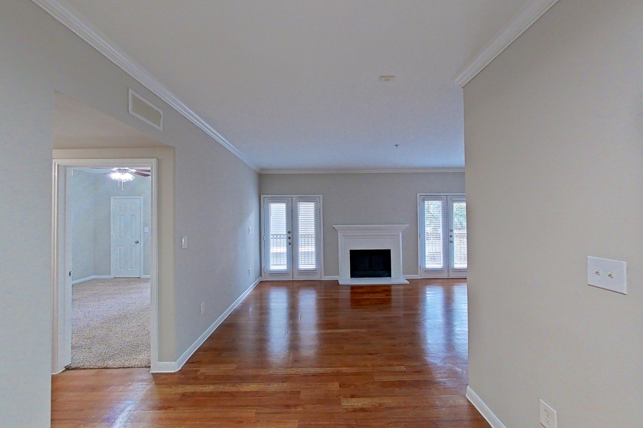 Dining area with dishwasher, electric range, fireplace, light stone countertops, light wood-finish flooring, oven/range, refrigerator, and stainless steel appliances, Apartment 1427 at Marquis on Westheimer