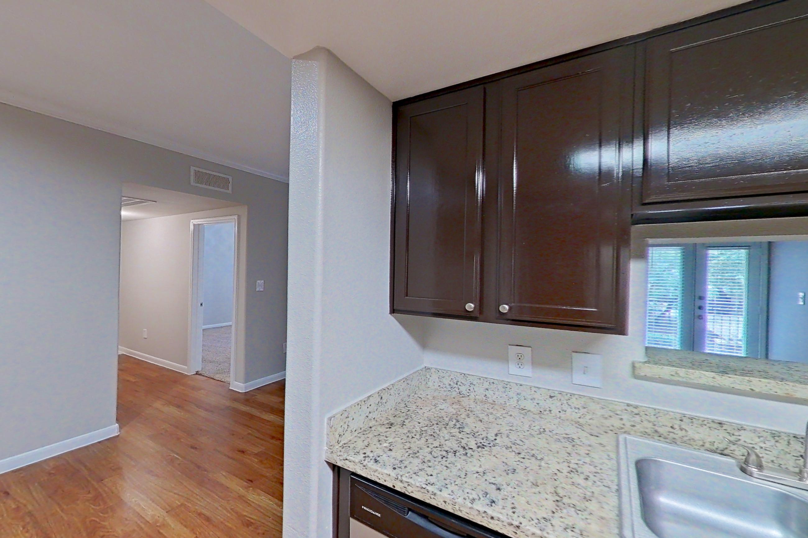 Kitchen with electric range, light stone countertops, light wood-finish flooring, microwave, oven/range, refrigerator, and stainless steel appliances, Apartment 1427 at Marquis on Westheimer