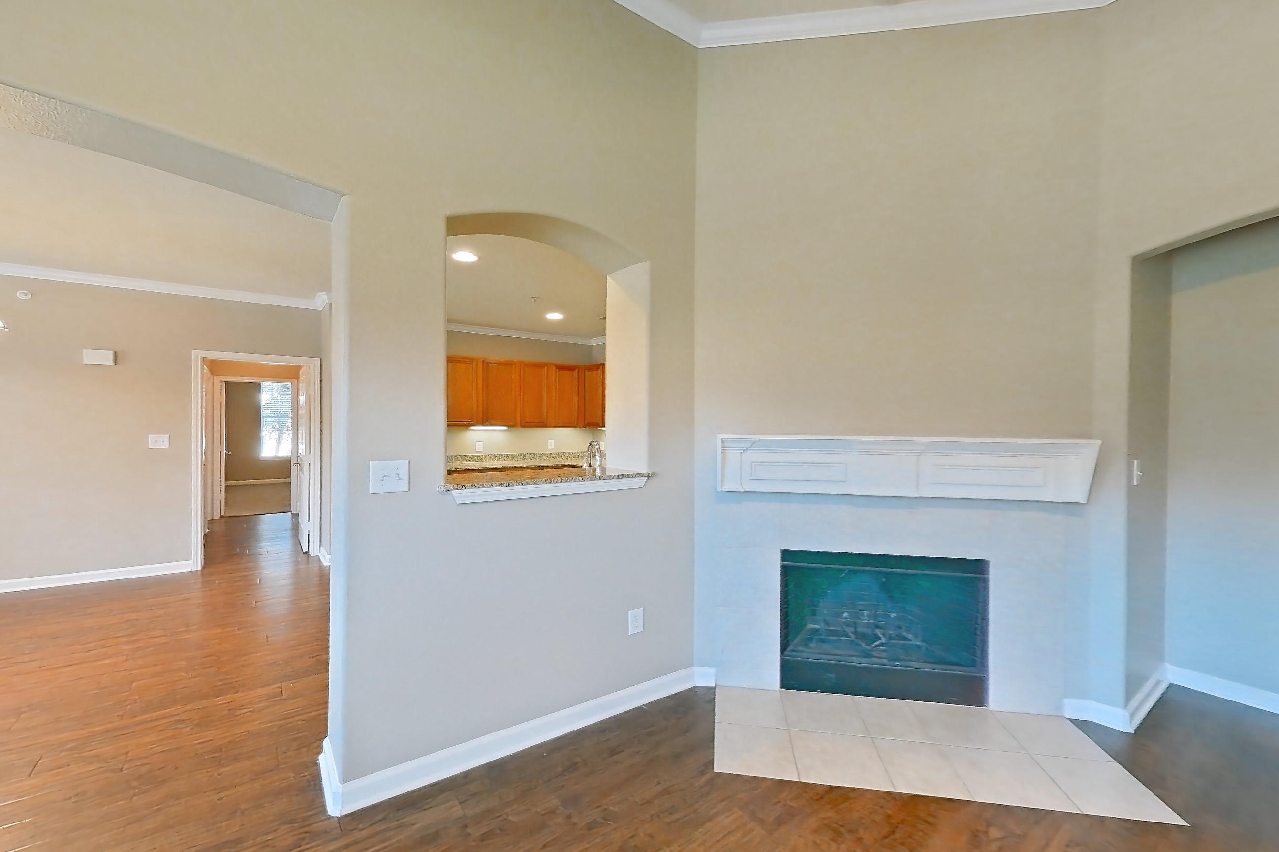 Living room with dark wood-finish flooring, fireplace, tile fireplace, and wood-finish flooring, Apartment 1-0107 at Marquis at The Cascades I