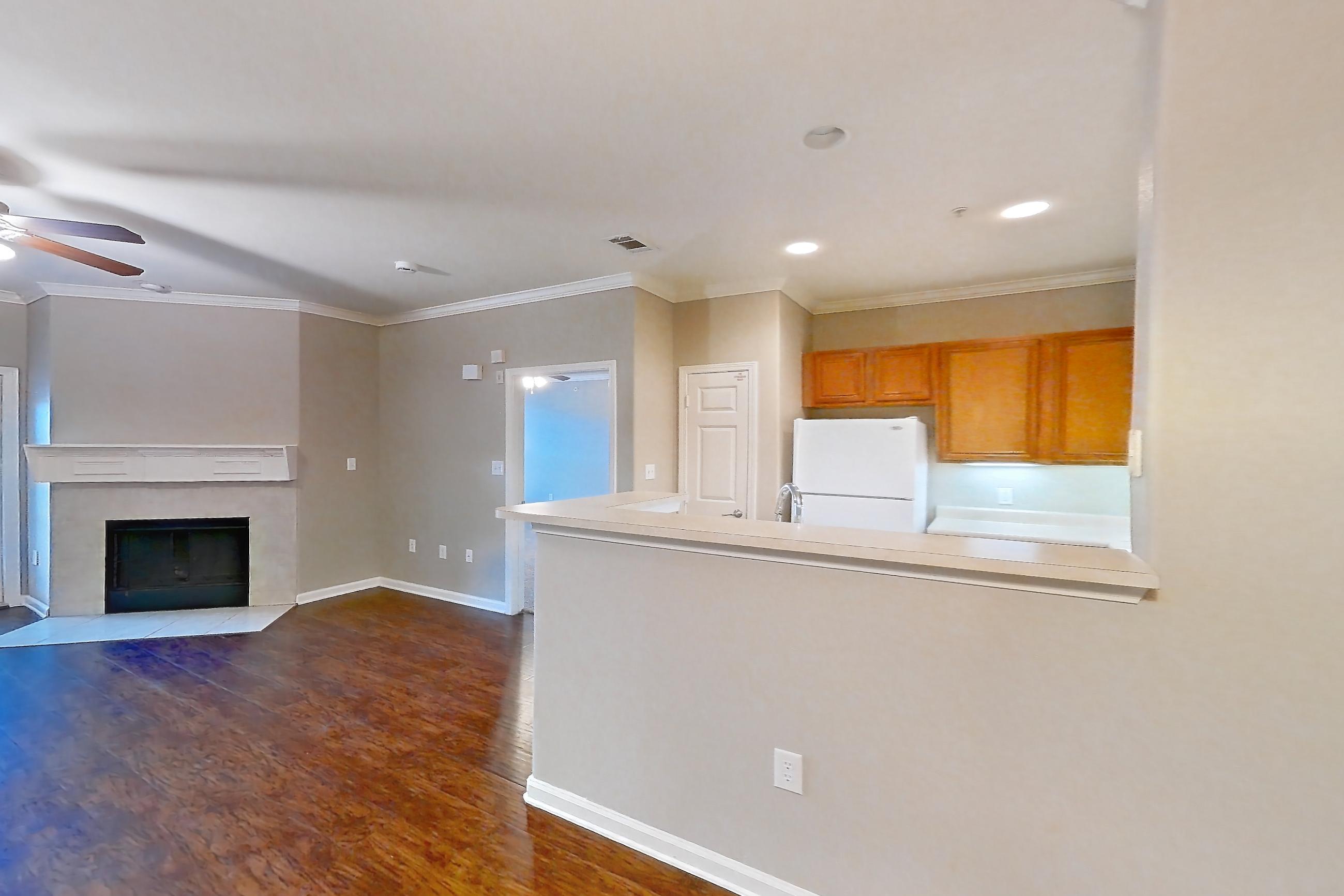 Dining room with dark tile flooring, dark wood-finish flooring, fireplace, refrigerator, tile fireplace, and white appliances, Apartment 1-0603 at Marquis at The Cascades I