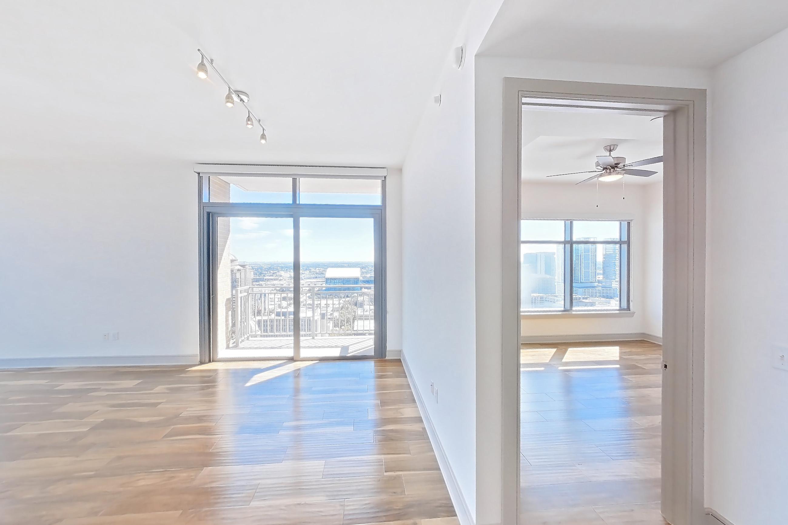 Kitchen space with dark countertops, dishwasher, light wood-finish flooring, oven/range, refrigerator, and stainless steel appliances, Apartment 2810 at Aris Market Square