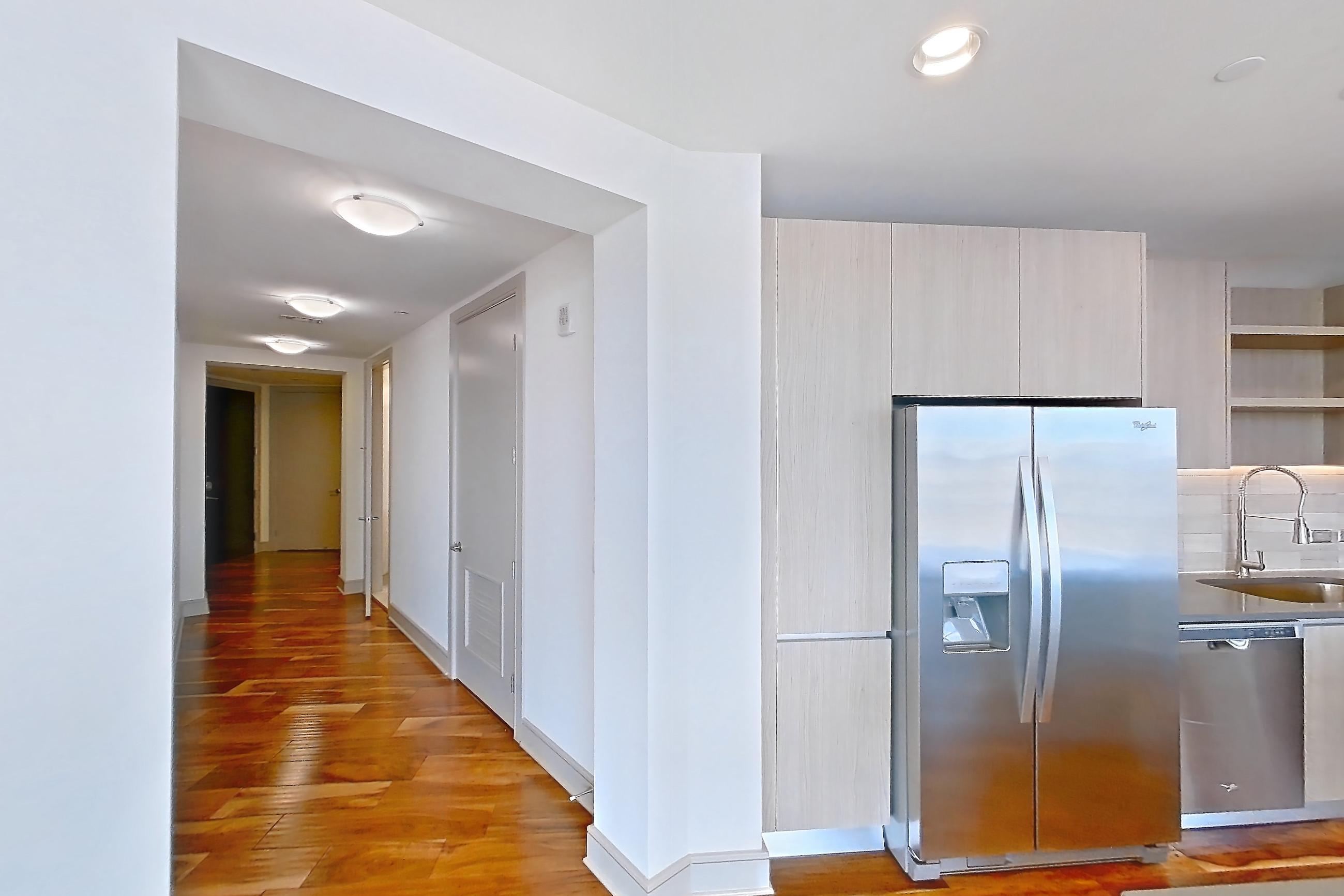 Kitchen space with dark countertops, dishwasher, light wood-finish flooring, oven/range, refrigerator, and stainless steel appliances, Apartment 2810 at Aris Market Square
