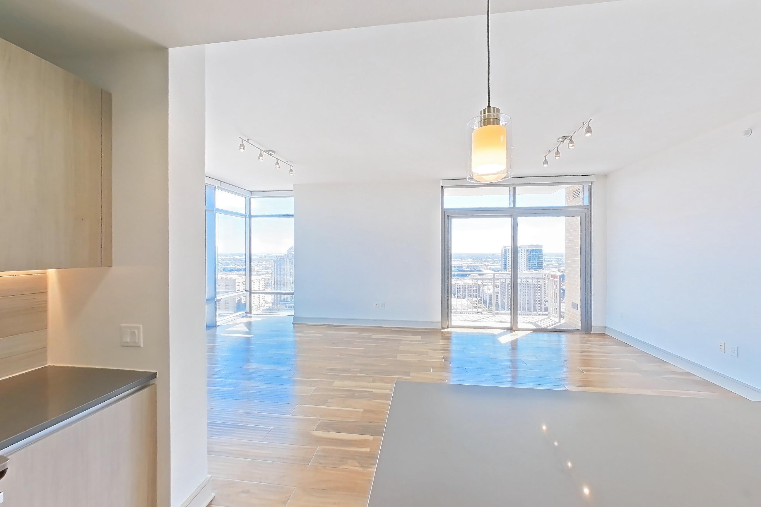 Kitchen with dark countertops, gas range, light countertops, light wood-finish flooring, oven/range, refrigerator, stainless steel appliances, and water & ice dispenser, Apartment 2810 at Aris Market Square